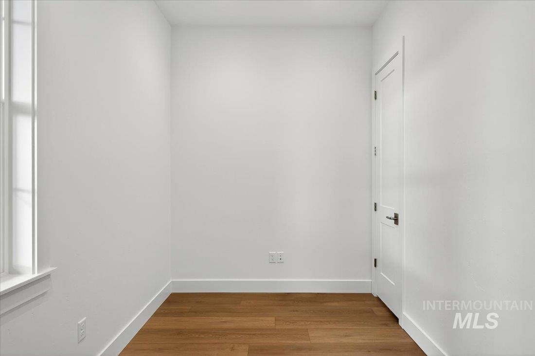 Unfurnished room with wood finished floors and baseboards