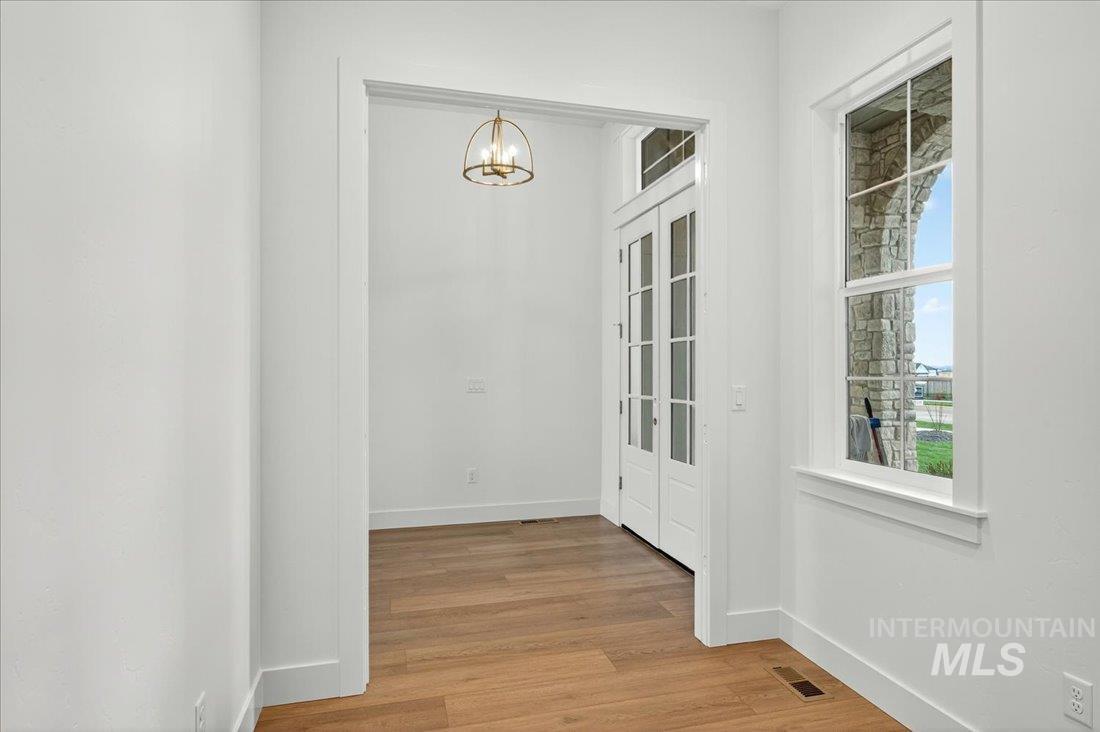 Unfurnished dining area featuring light wood-type flooring and a chandelier
