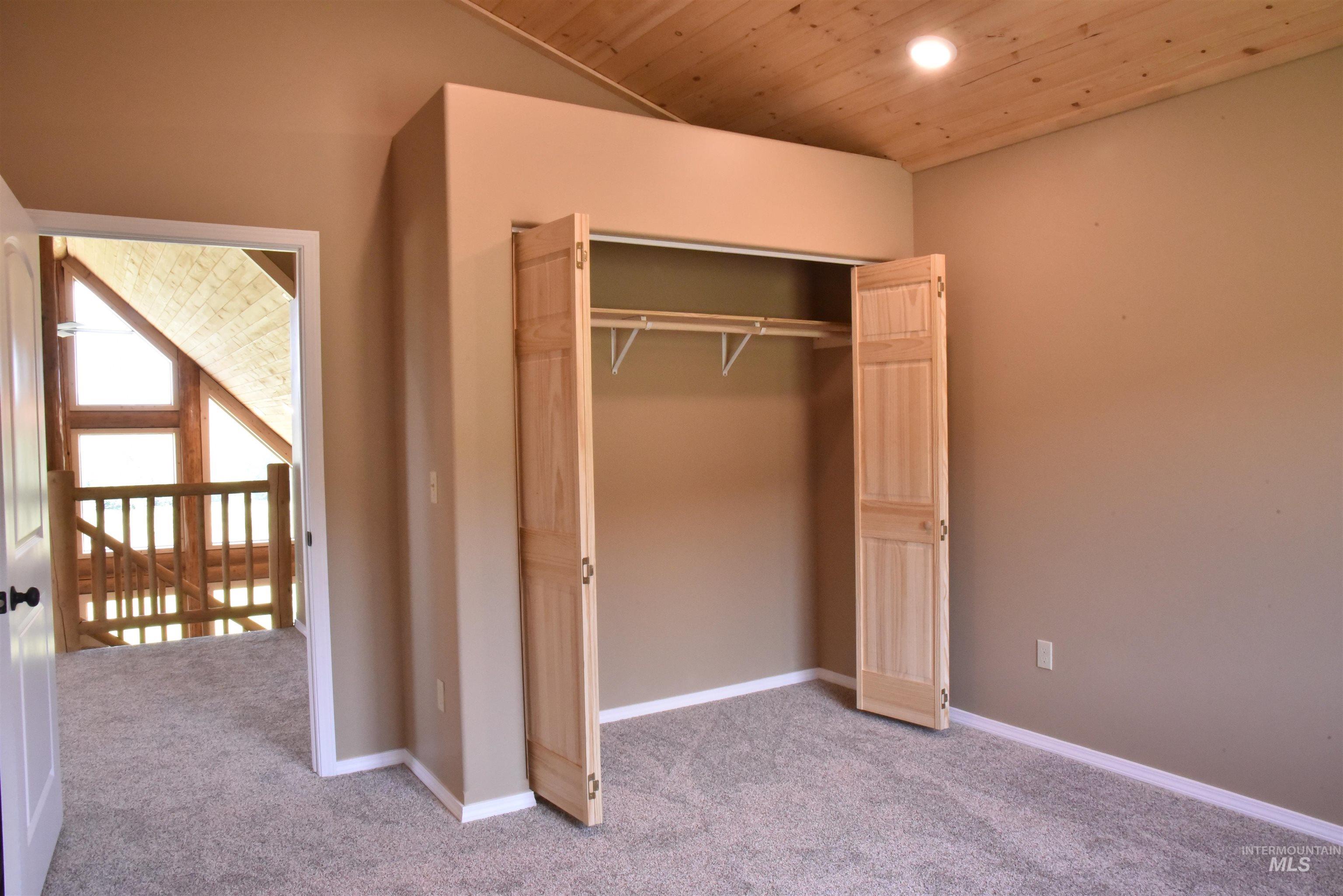 Unfurnished bedroom with carpet, wooden ceiling, recessed lighting, and a closet