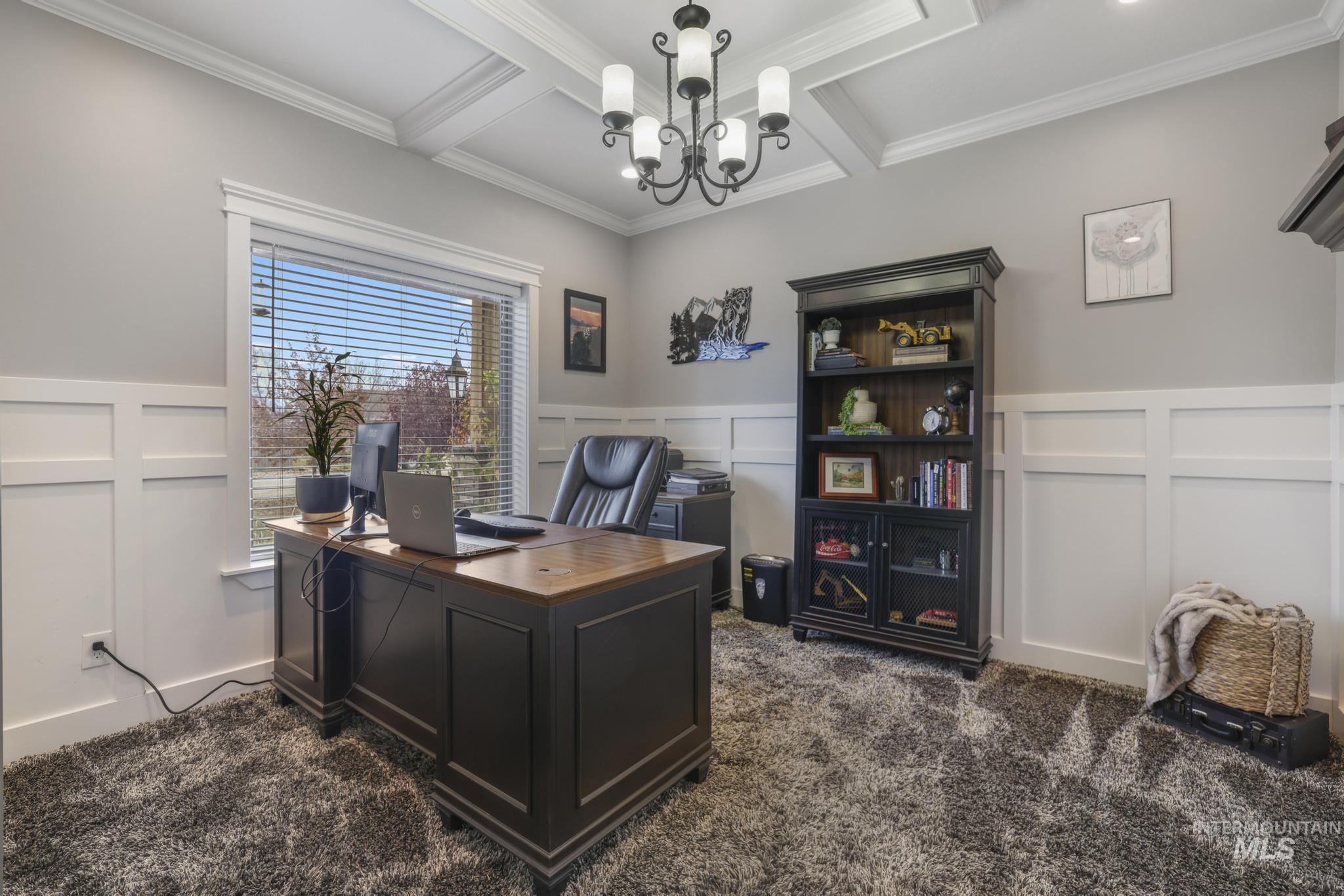 Office area featuring a decorative wall, dark carpet, beamed ceiling, coffered ceiling, and a wainscoted wall