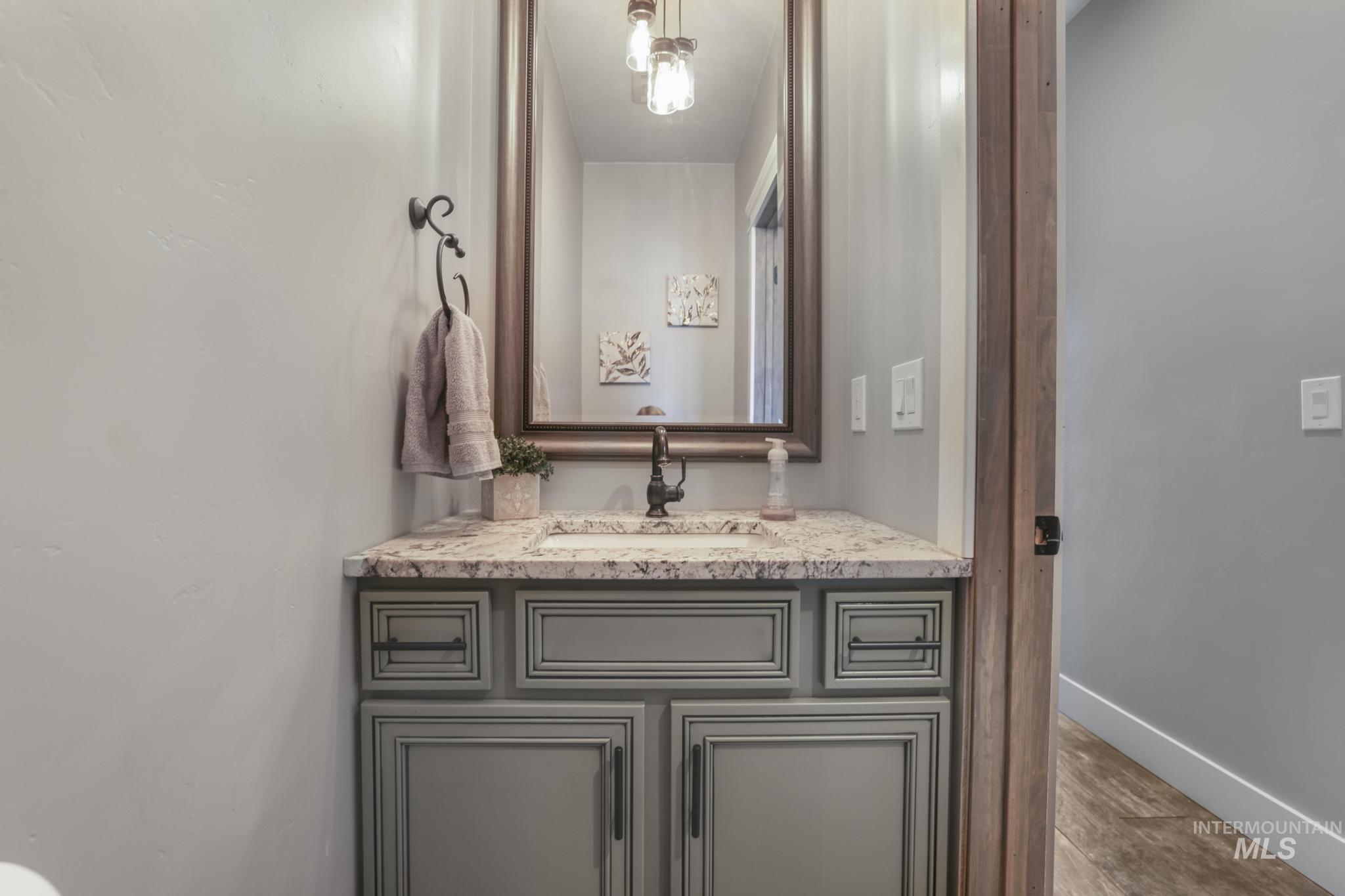 Half bath featuring vanity and wood finished floors