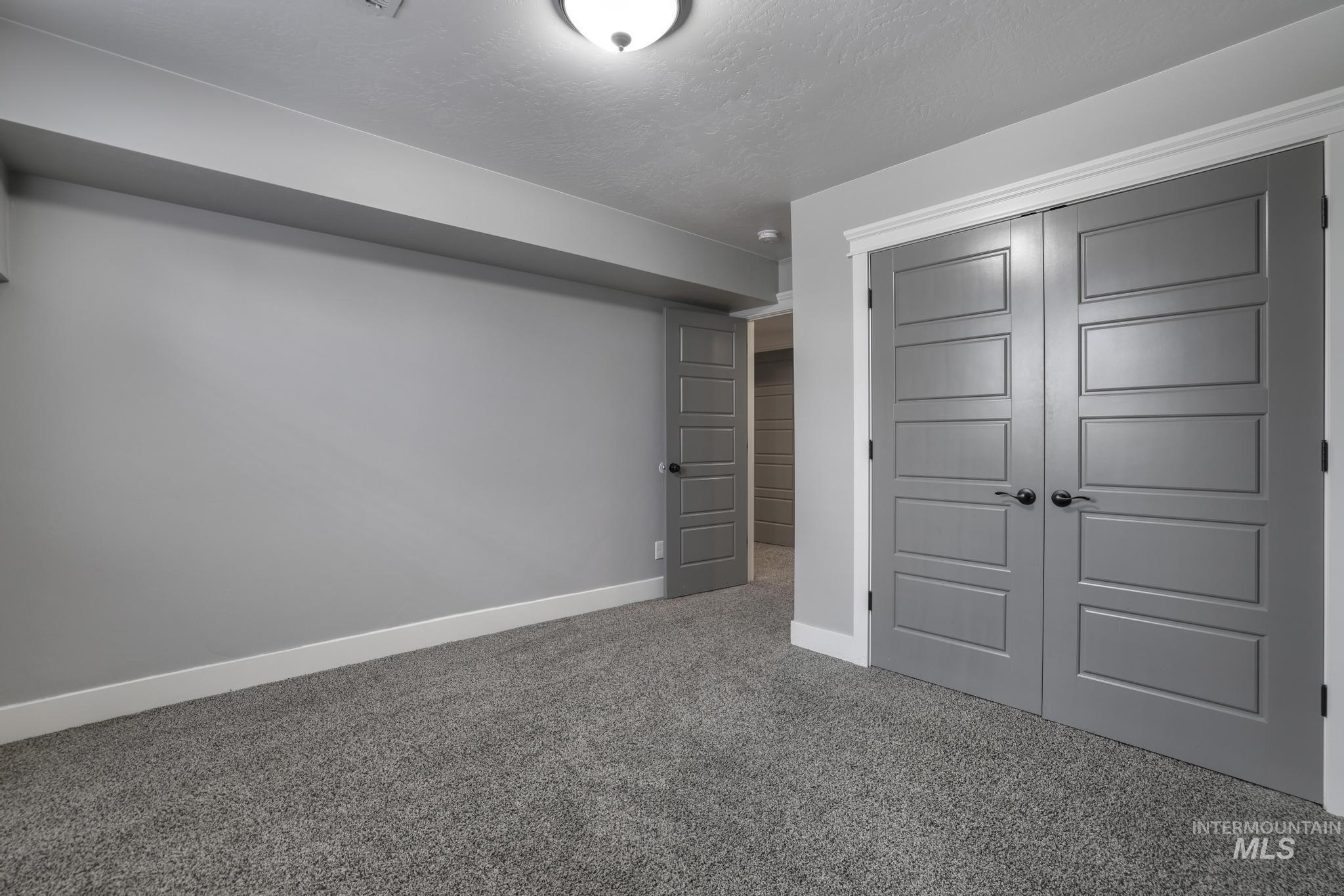 Unfurnished bedroom featuring carpet, a closet, and a textured ceiling