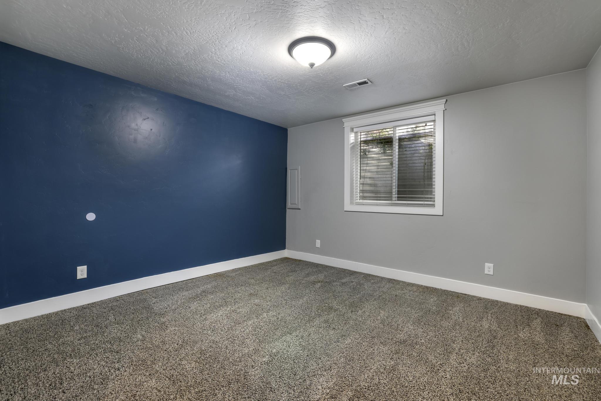 Spare room with a textured ceiling and carpet