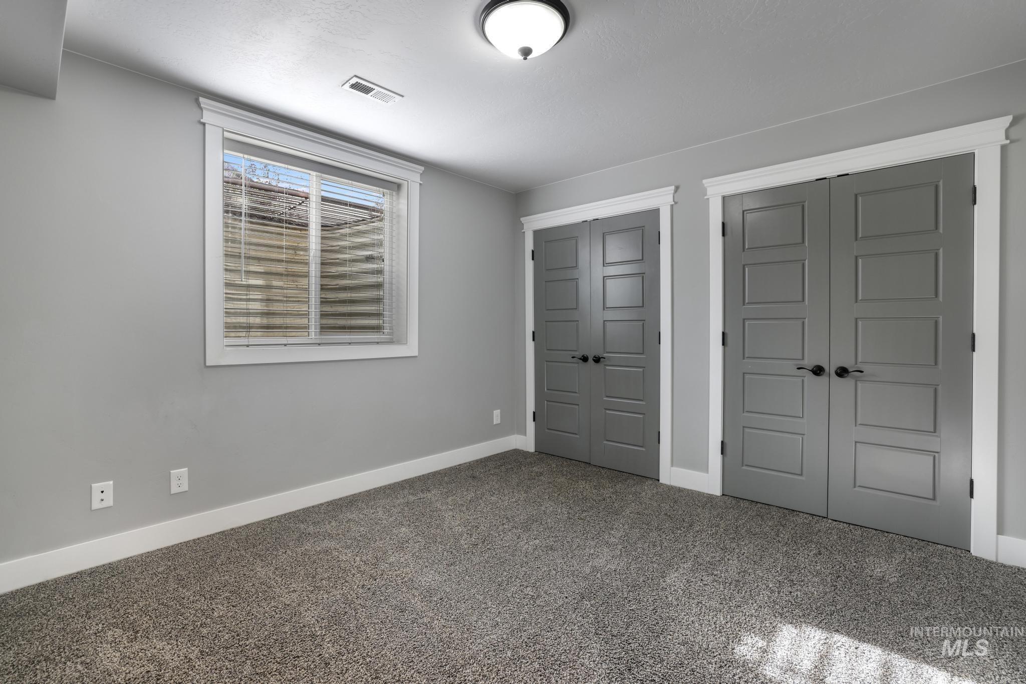 Unfurnished bedroom featuring two closets and carpet