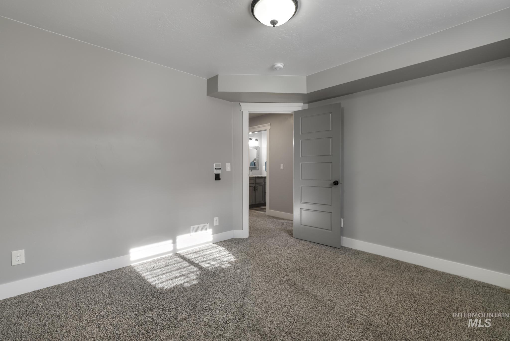 Carpeted spare room featuring baseboards