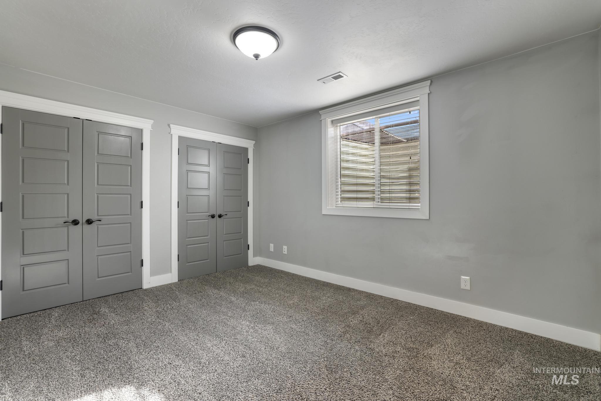 Unfurnished bedroom featuring two closets and carpet