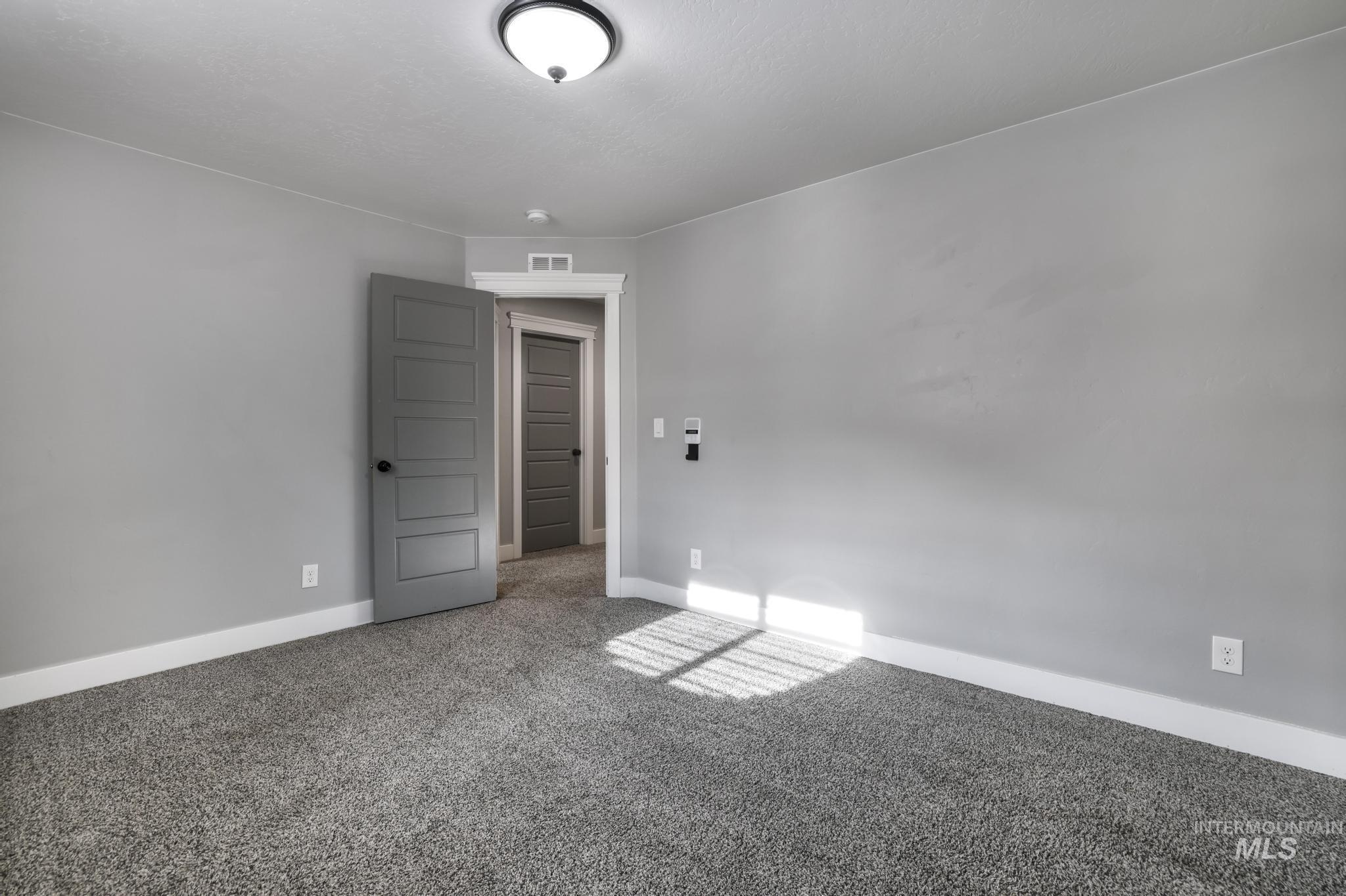 Carpeted empty room featuring baseboards