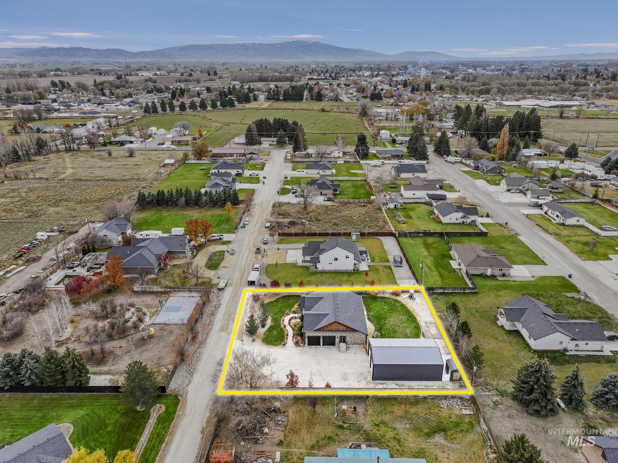 Aerial perspective of suburban area featuring property boundaries highlighted and mountains