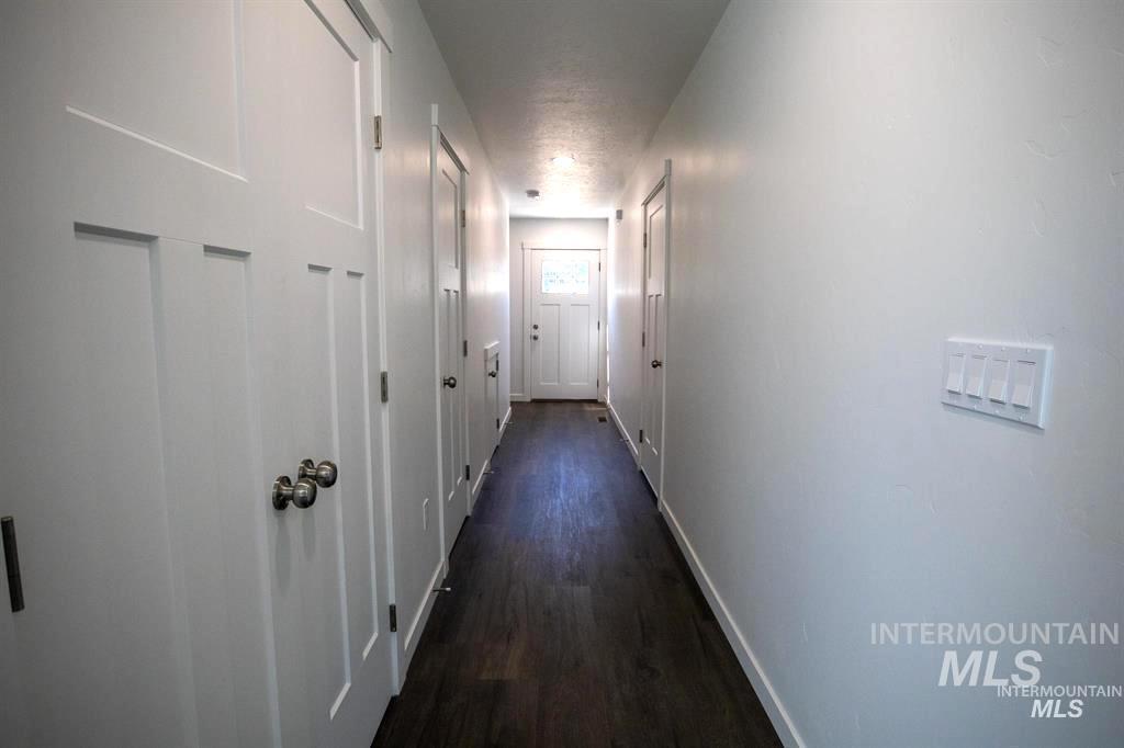 Hallway with dark wood-style flooring and baseboards
