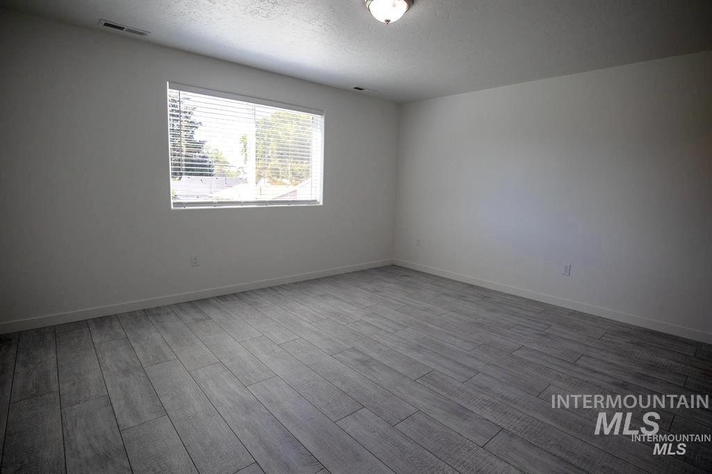 Unfurnished room featuring a textured ceiling and light wood-type flooring