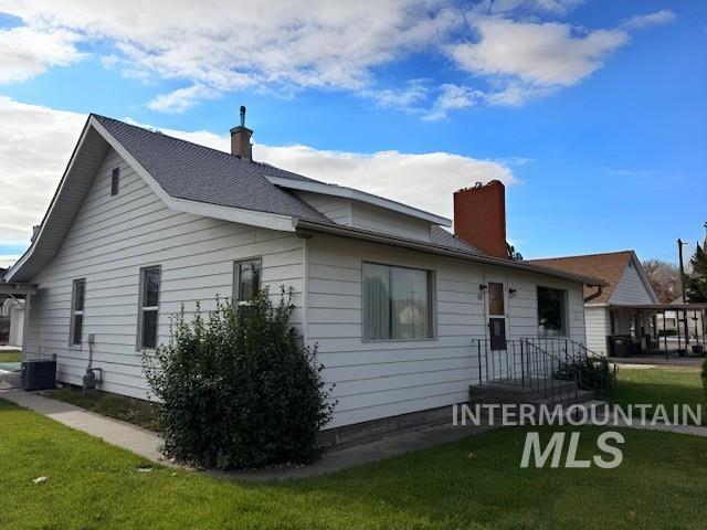 View of front of home with a chimney and a front yard