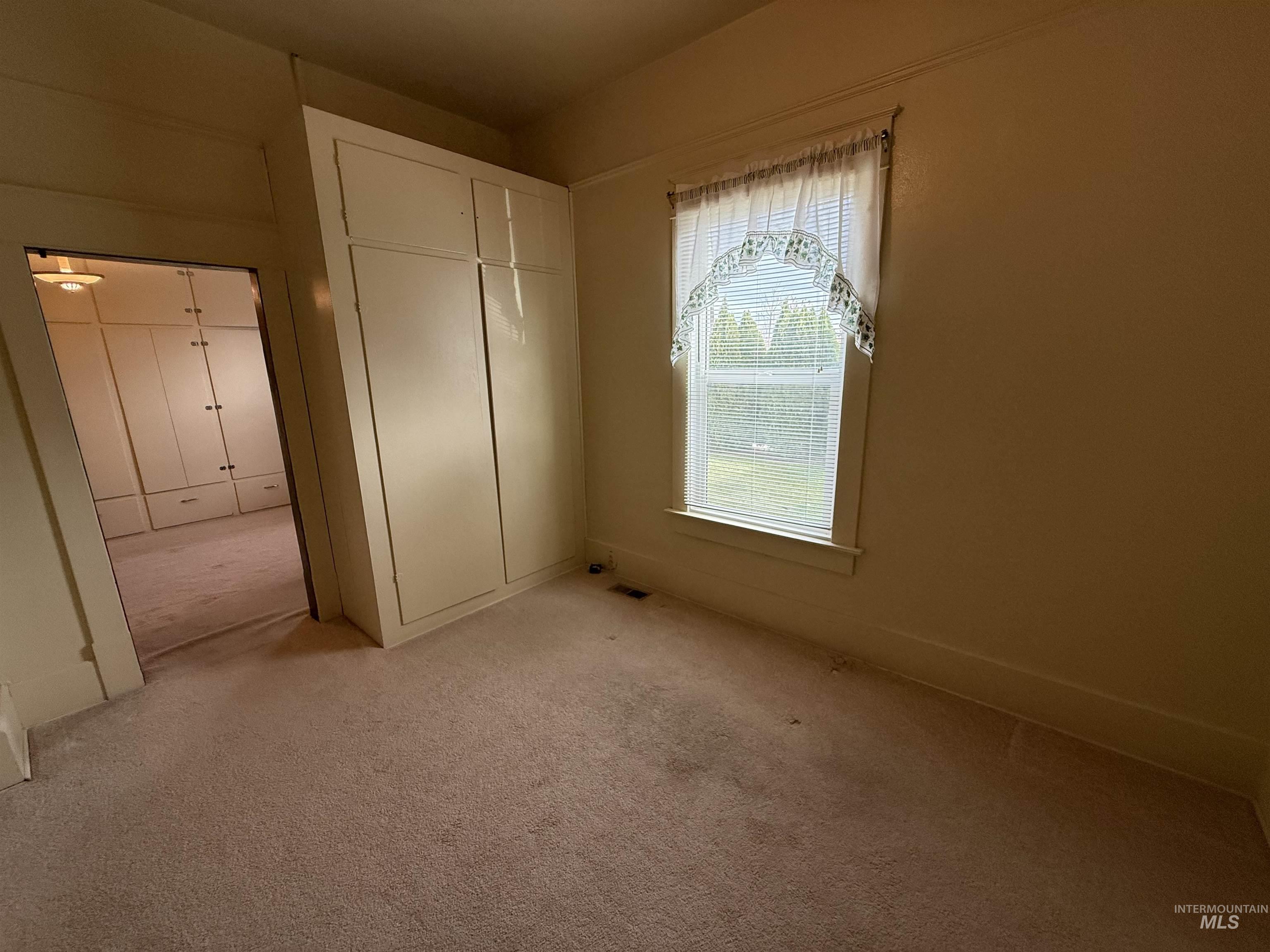 Unfurnished bedroom featuring carpet and a closet