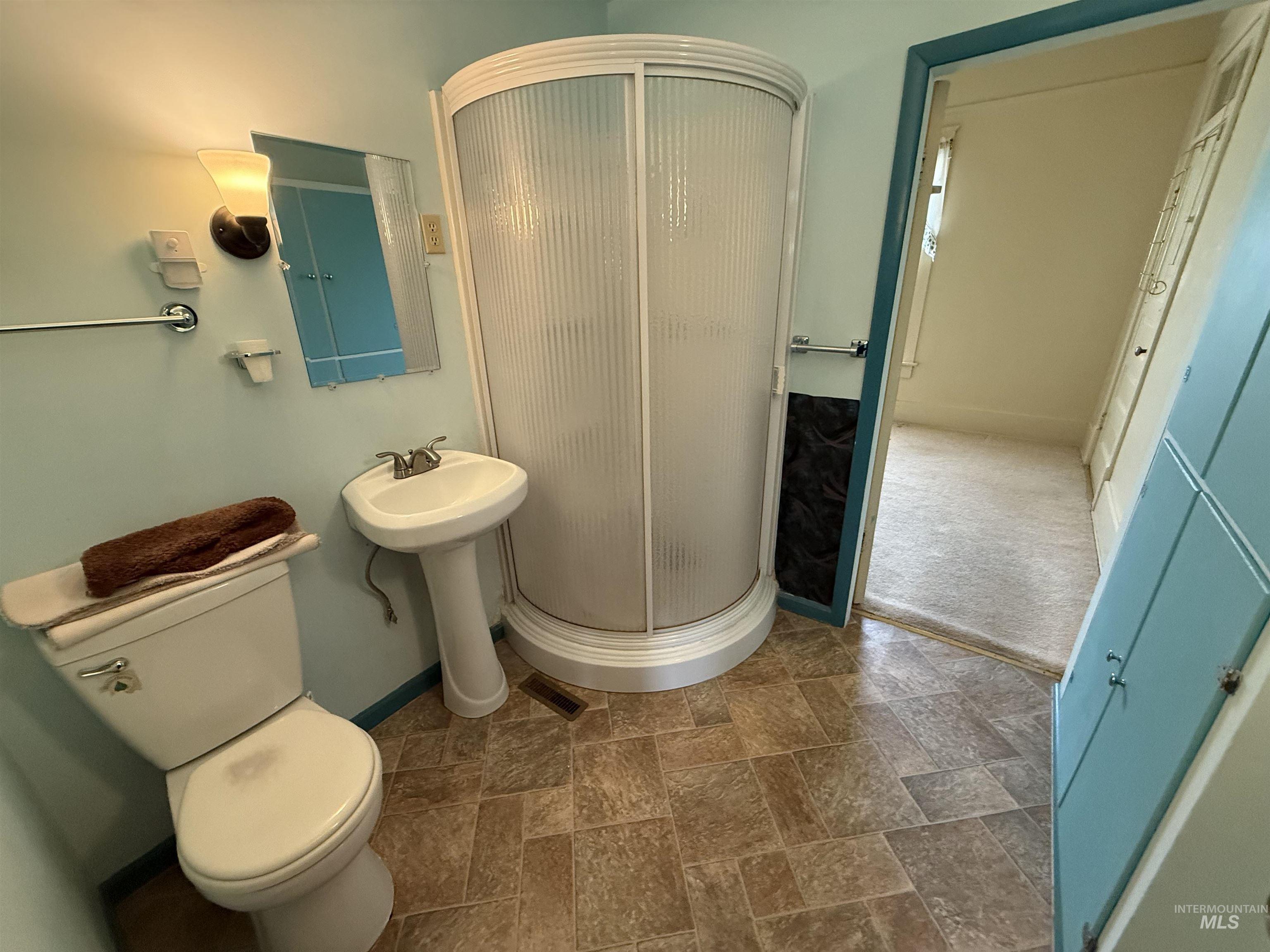 Full bathroom with a shower stall and stone finish floors