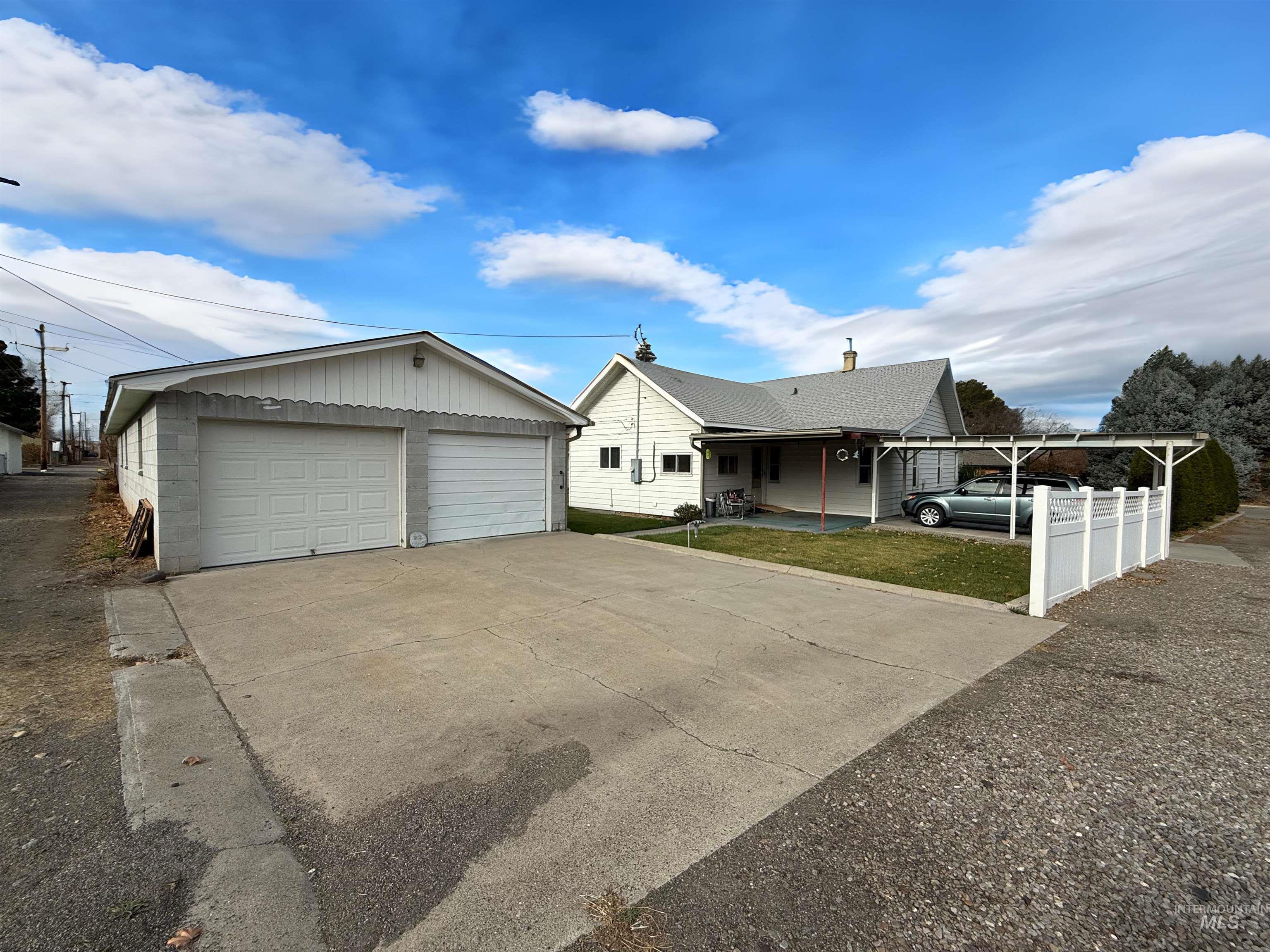 View of front facade with covered porch and a detached garage