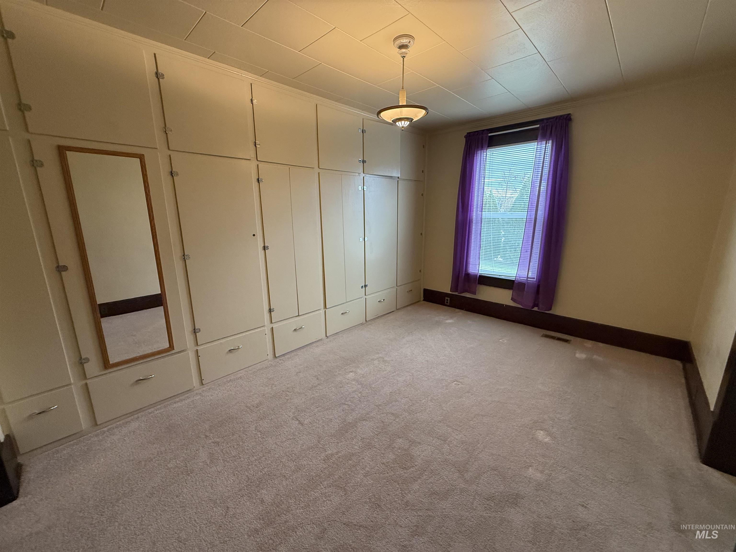 Unfurnished bedroom with carpet, ornamental molding, and a closet