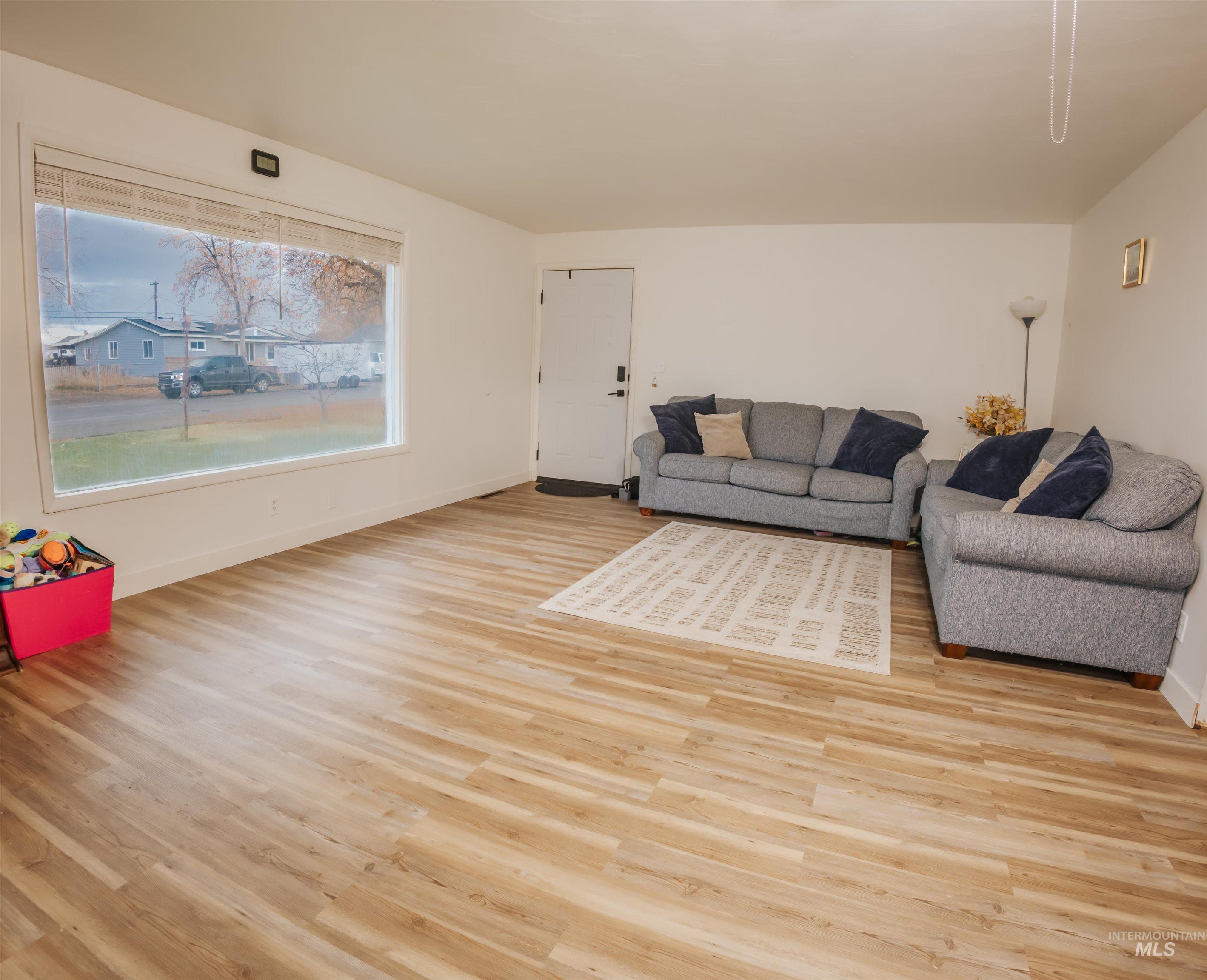 Living room with light wood-type flooring and baseboards