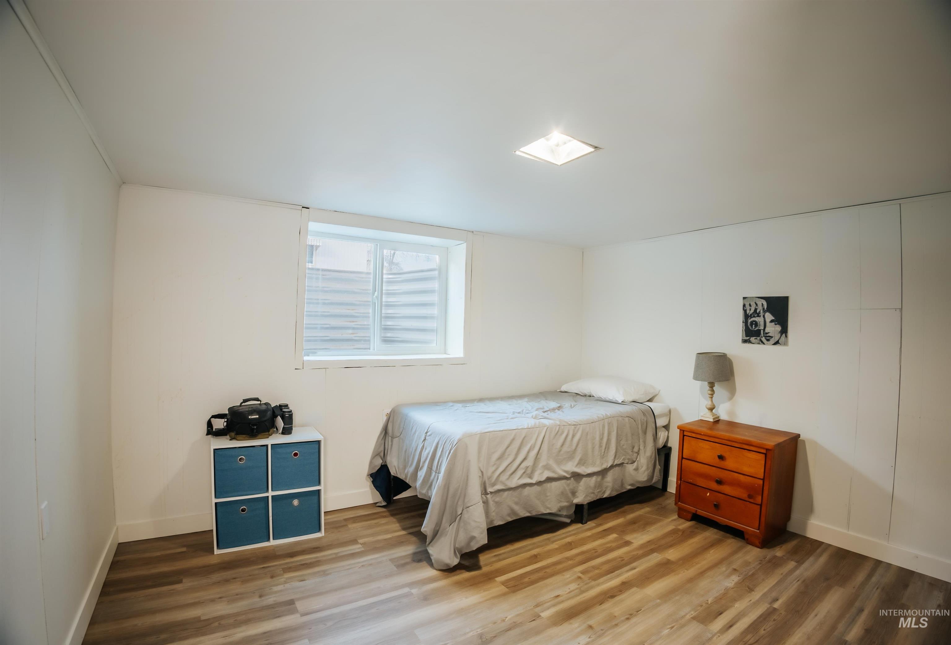 Bedroom featuring wood finished floors and baseboards