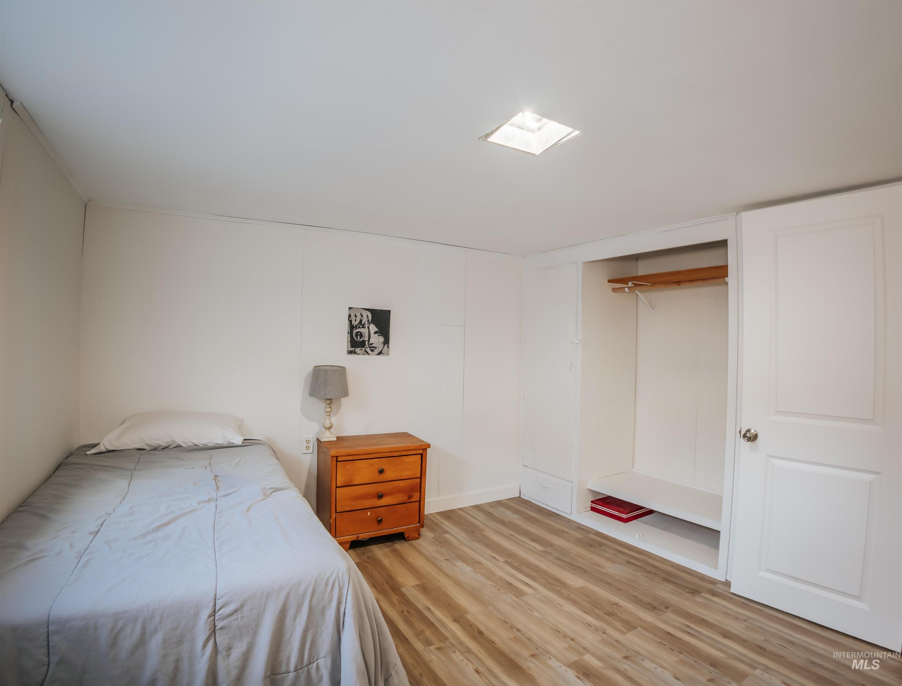 Bedroom featuring light wood finished floors and a closet