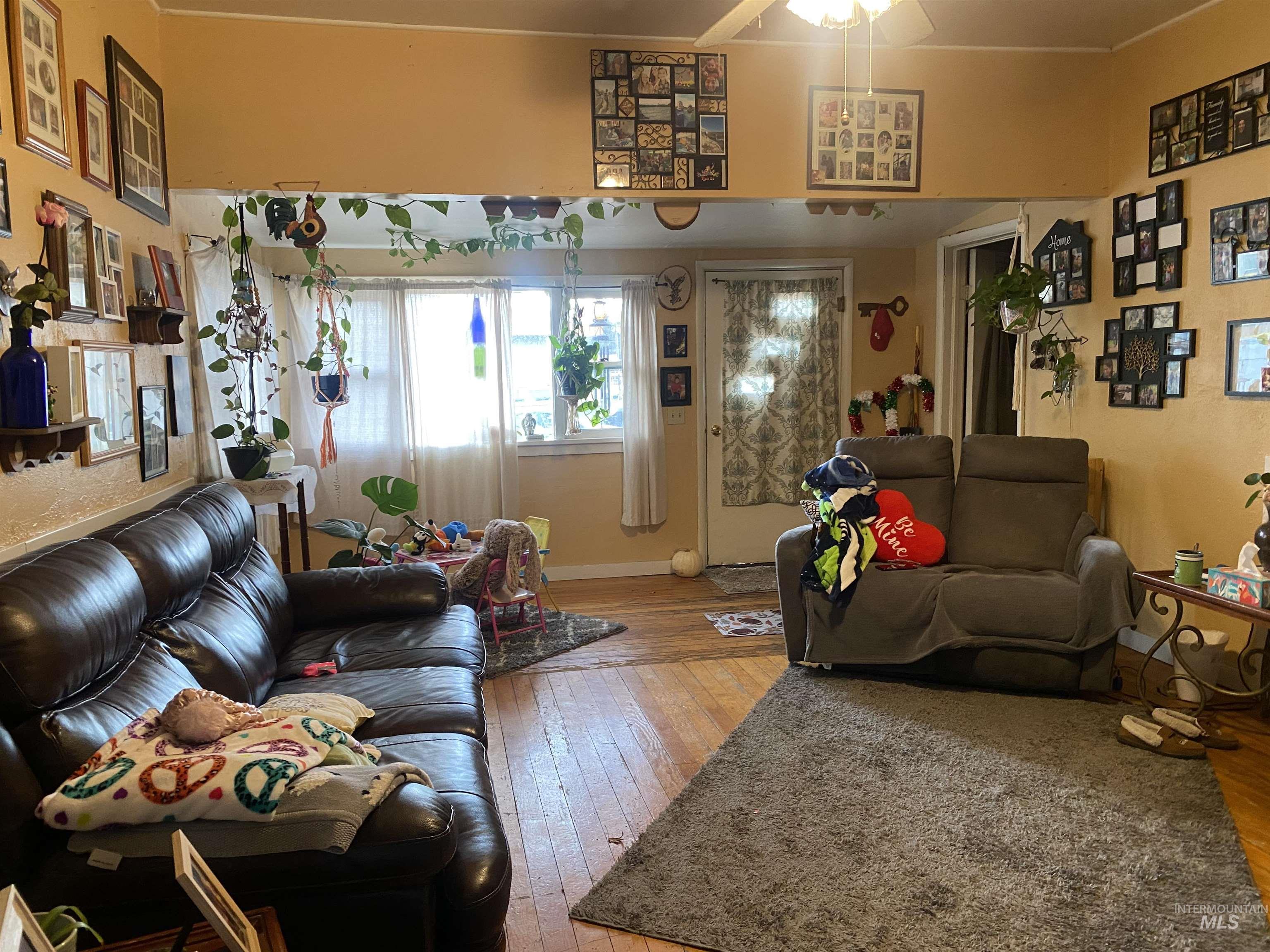 Living area with light wood-style floors and ceiling fan