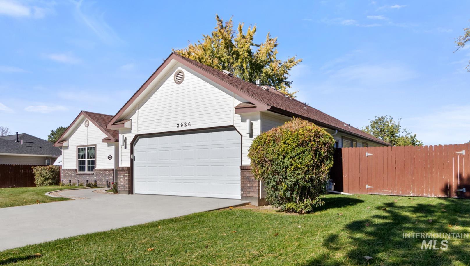 View of front facade featuring brick siding, driveway, and an attached garage