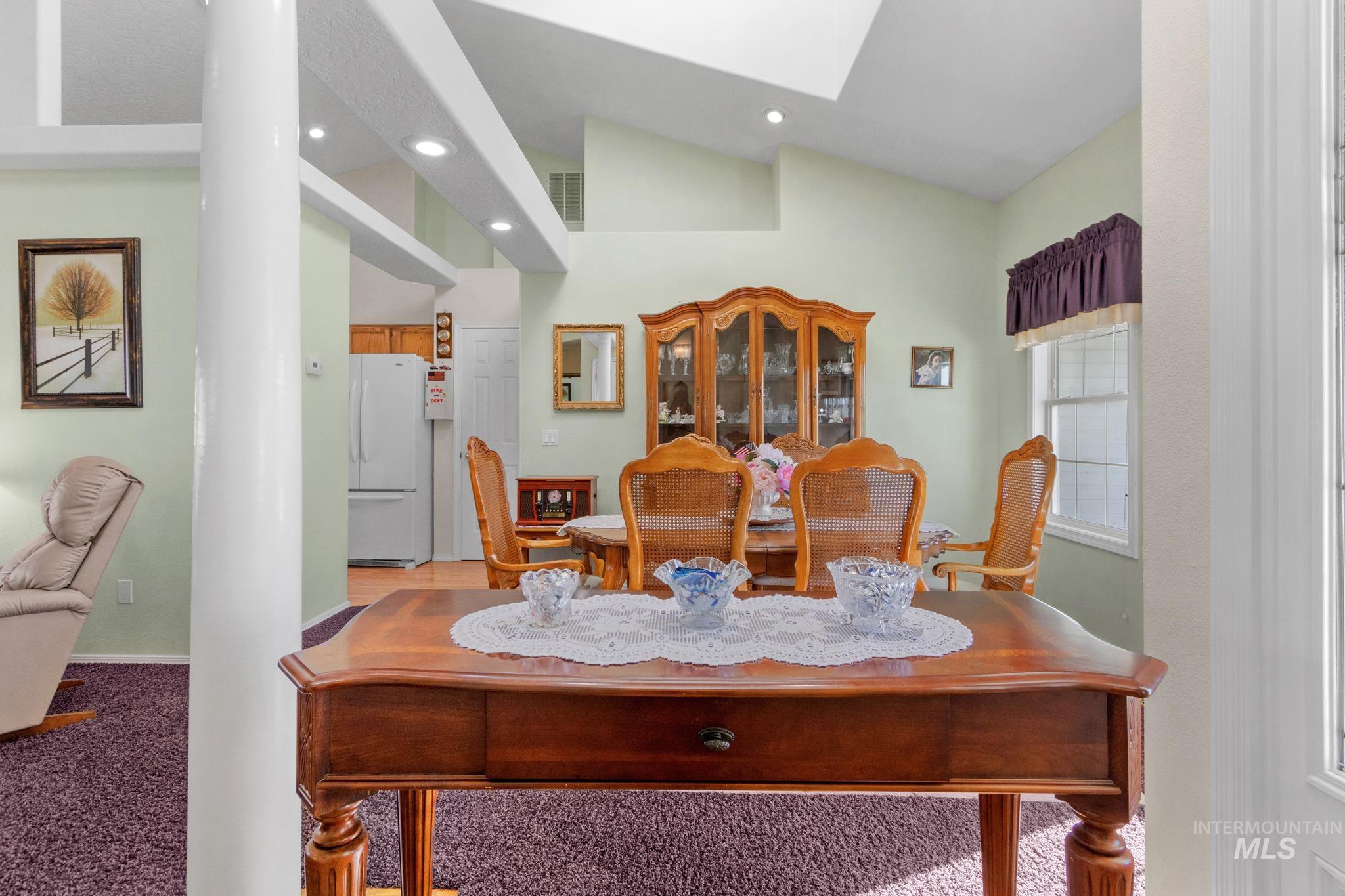 Dining space featuring vaulted ceiling, a skylight, recessed lighting, and carpet