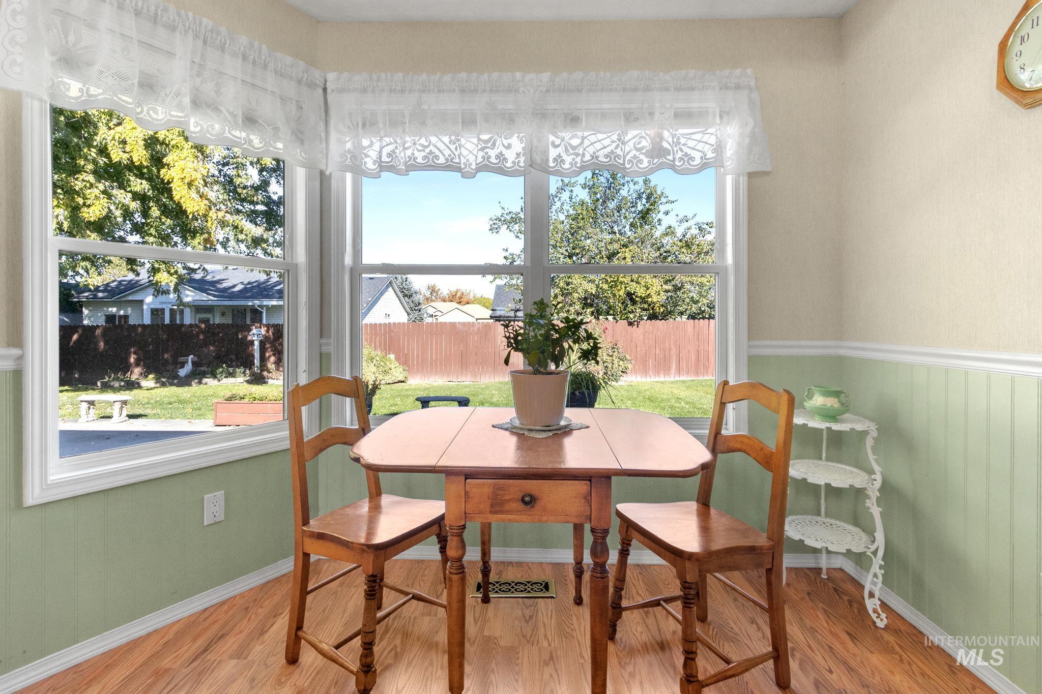 Dining space with wood finished floors and wainscoting
