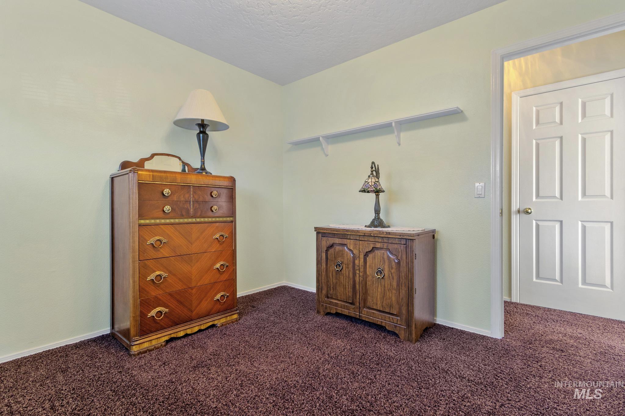 Living area with dark carpet and a textured ceiling