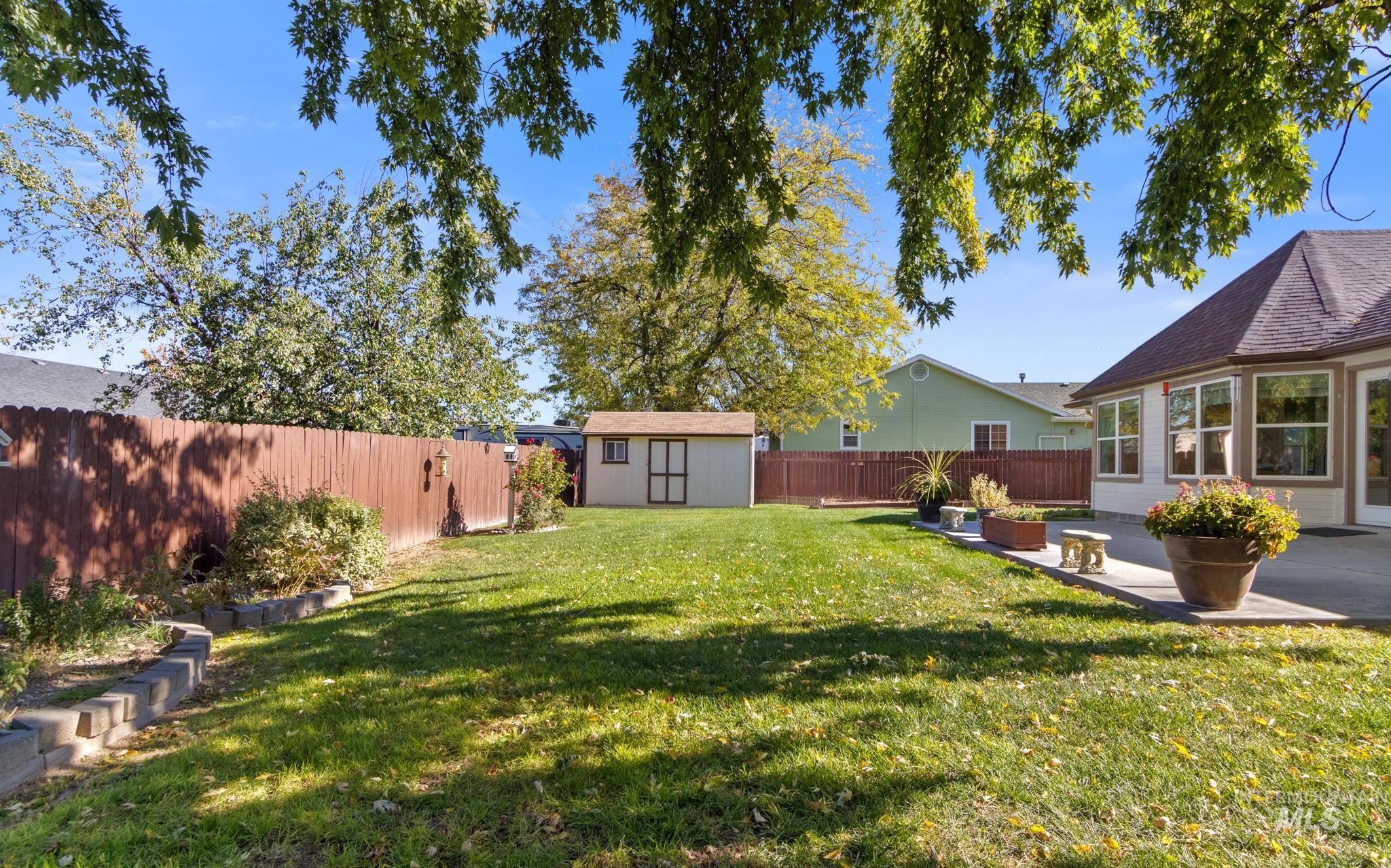 Fenced backyard with a shed and a patio area