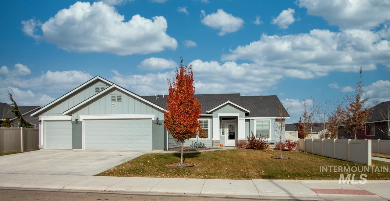 View of front of house featuring board and batten siding, driveway, an attached garage, and a shingled roof