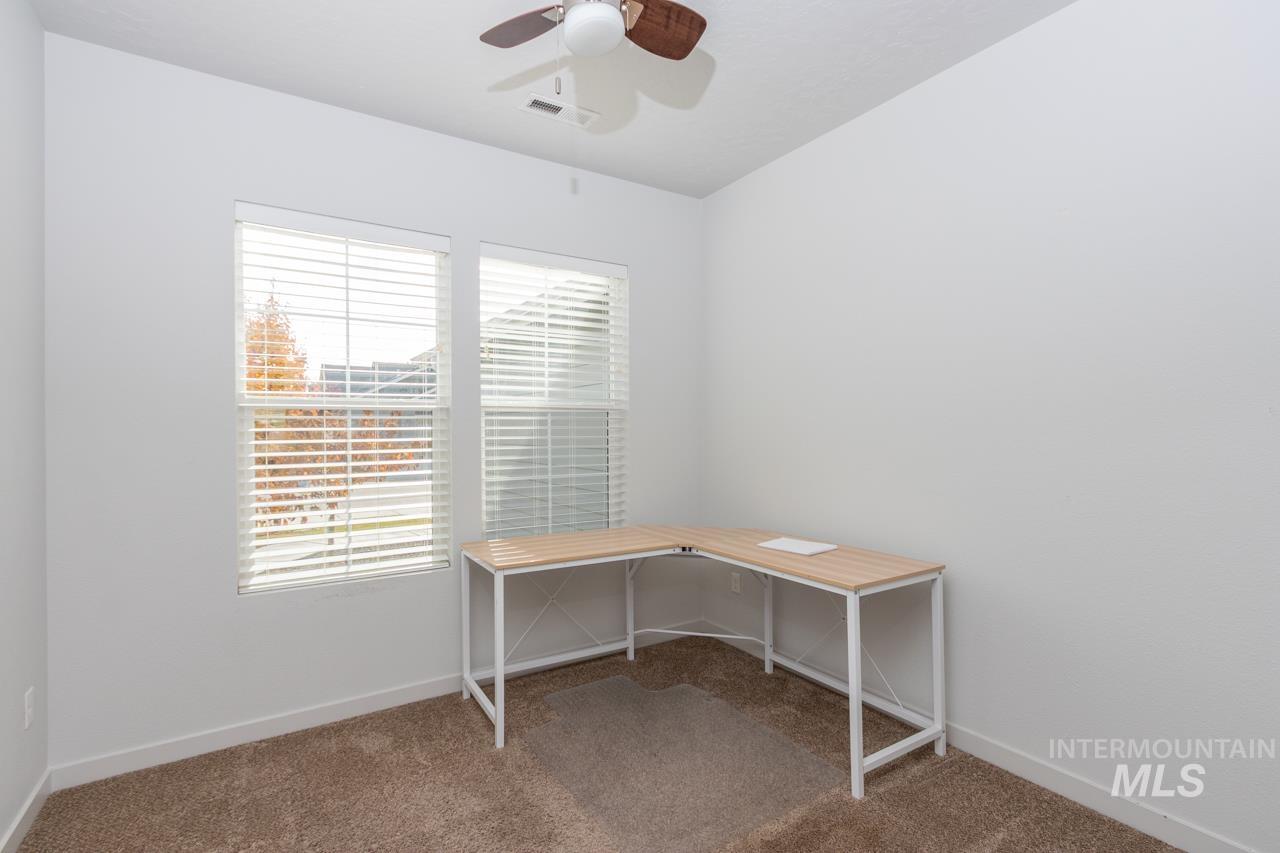 Unfurnished office featuring light carpet and a ceiling fan. Could be considered bedroom 4 with closet