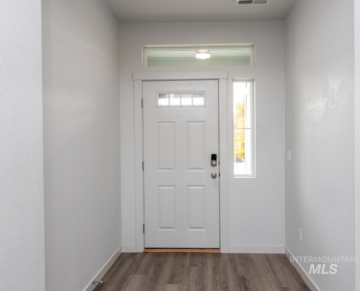 Entryway featuring dark wood-style flooring and baseboards