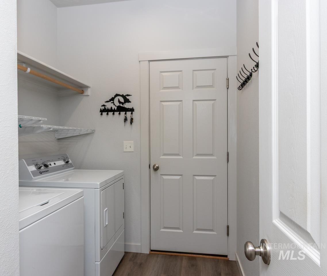 Laundry area featuring dark wood-type flooring and washer and clothes dryer