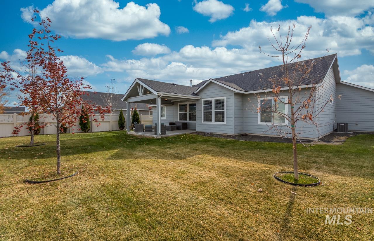 Back of property featuring a patio area, roof with shingles, and a ceiling fan