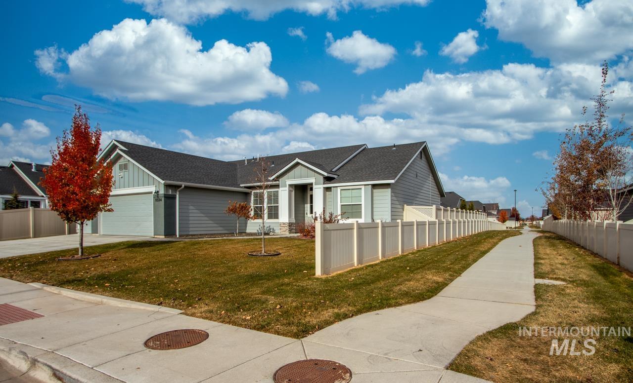 View of front facade with board and batten siding, roof with shingles, and driveway