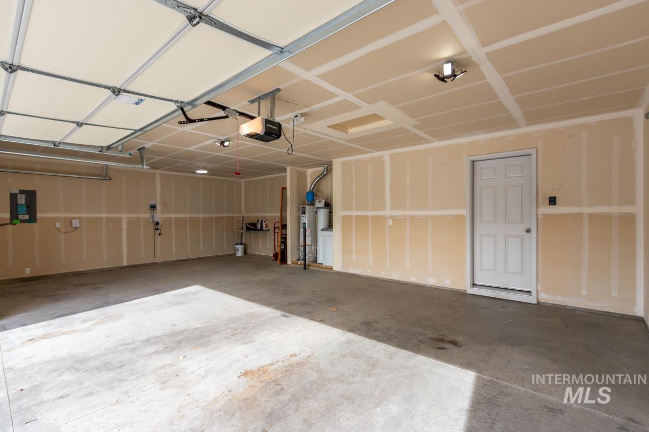 Garage featuring electric panel and a garage door opener