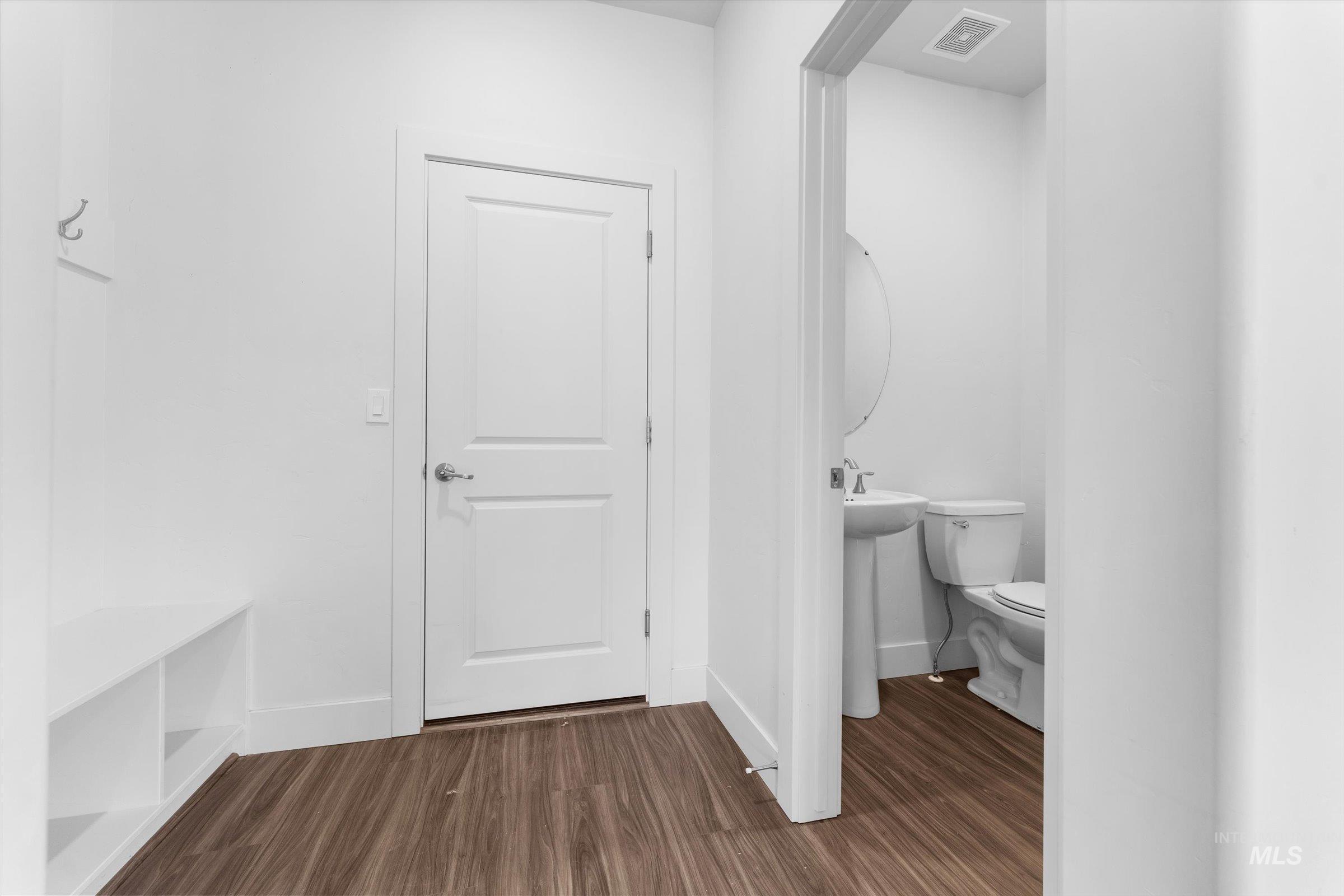 Half bath with dark wood-style floors and baseboards