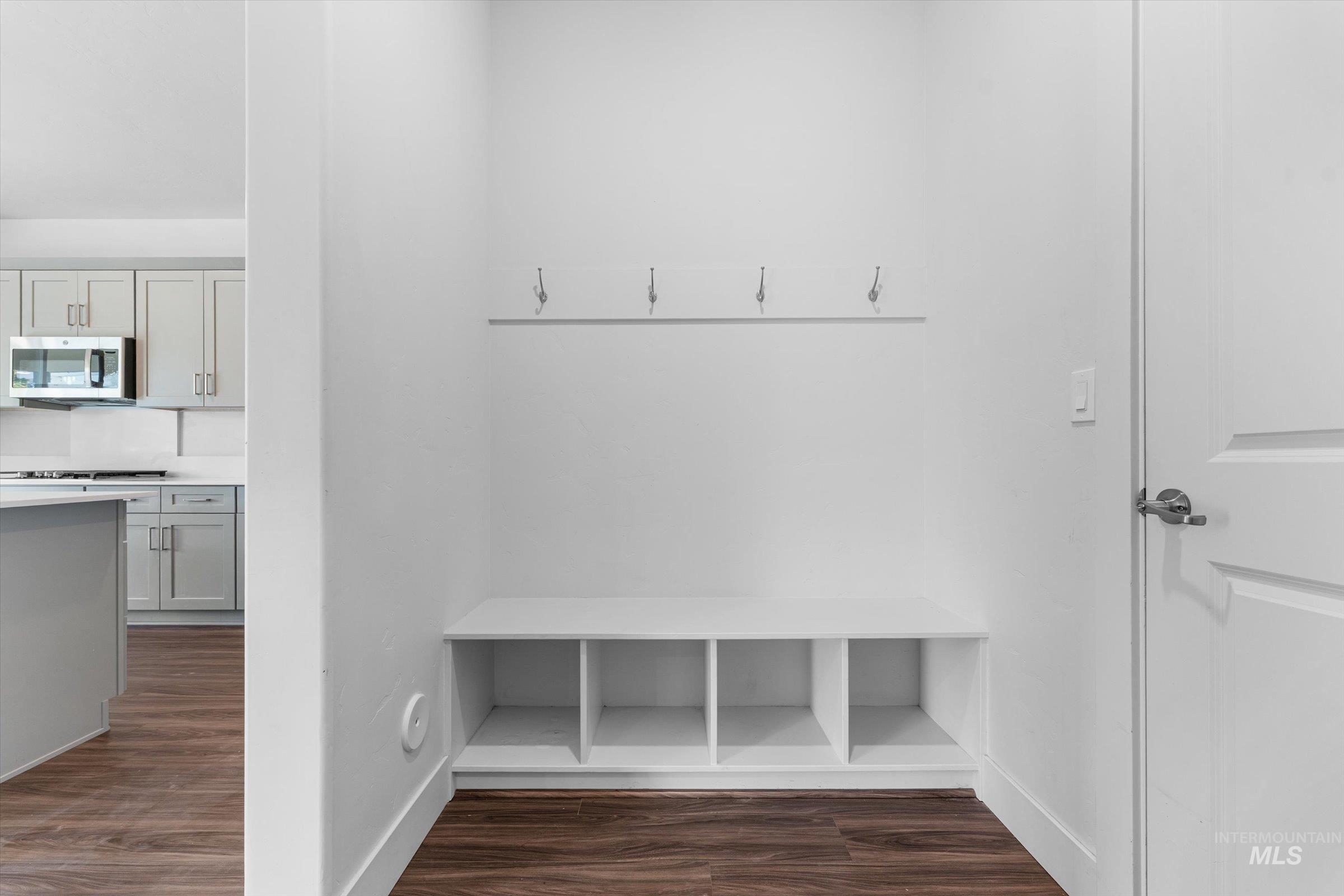 Mudroom with dark wood-style flooring and baseboards
