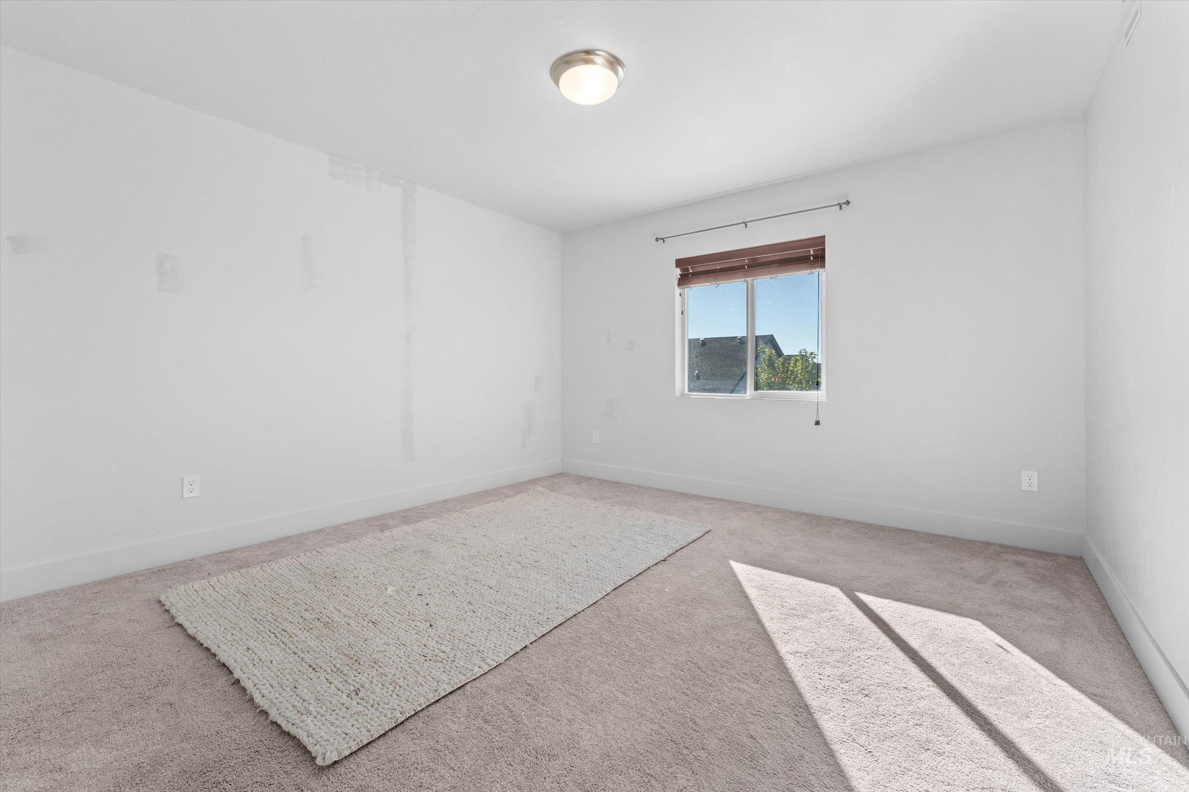 Spare room with carpet and baseboards