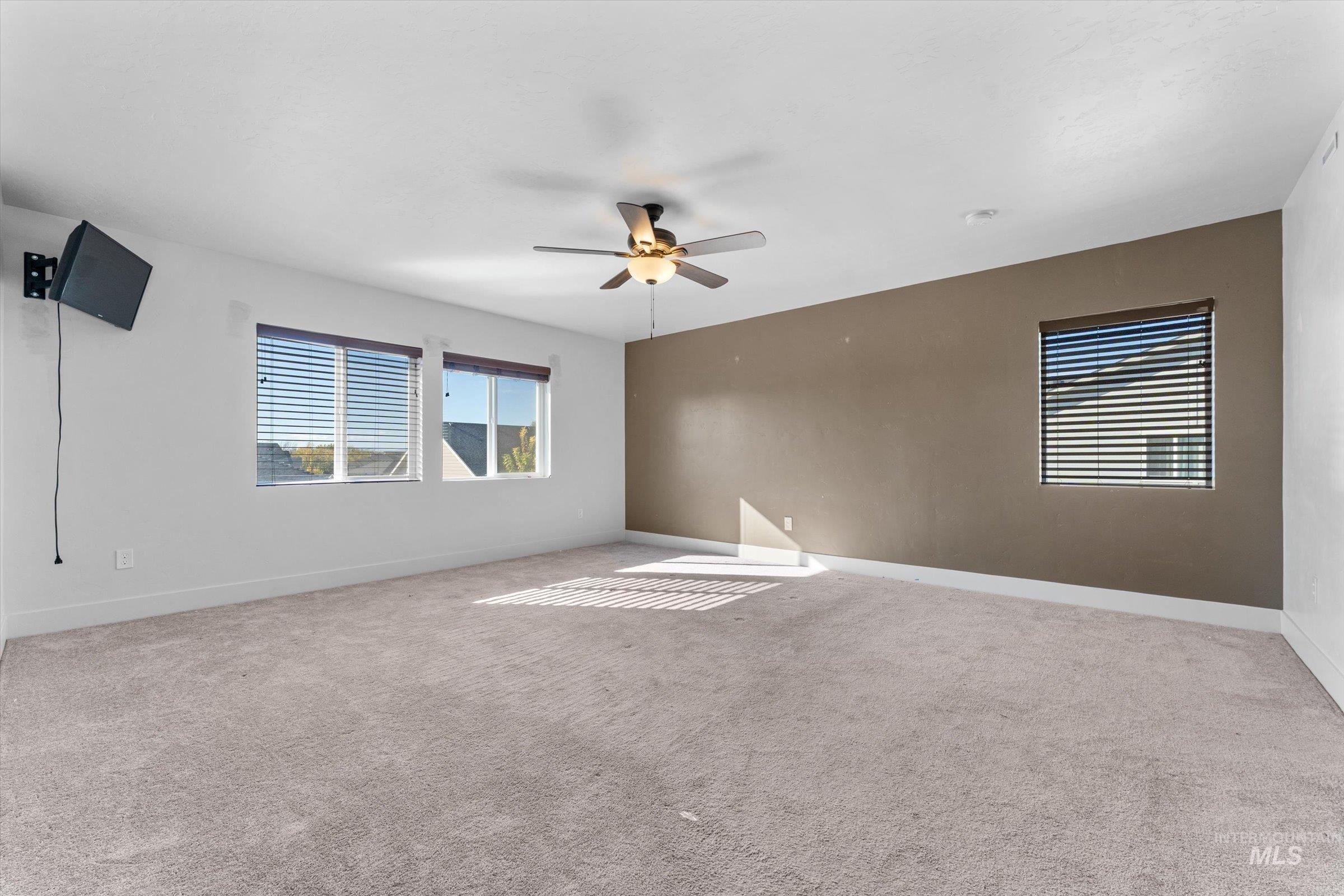Spare room with light colored carpet and ceiling fan