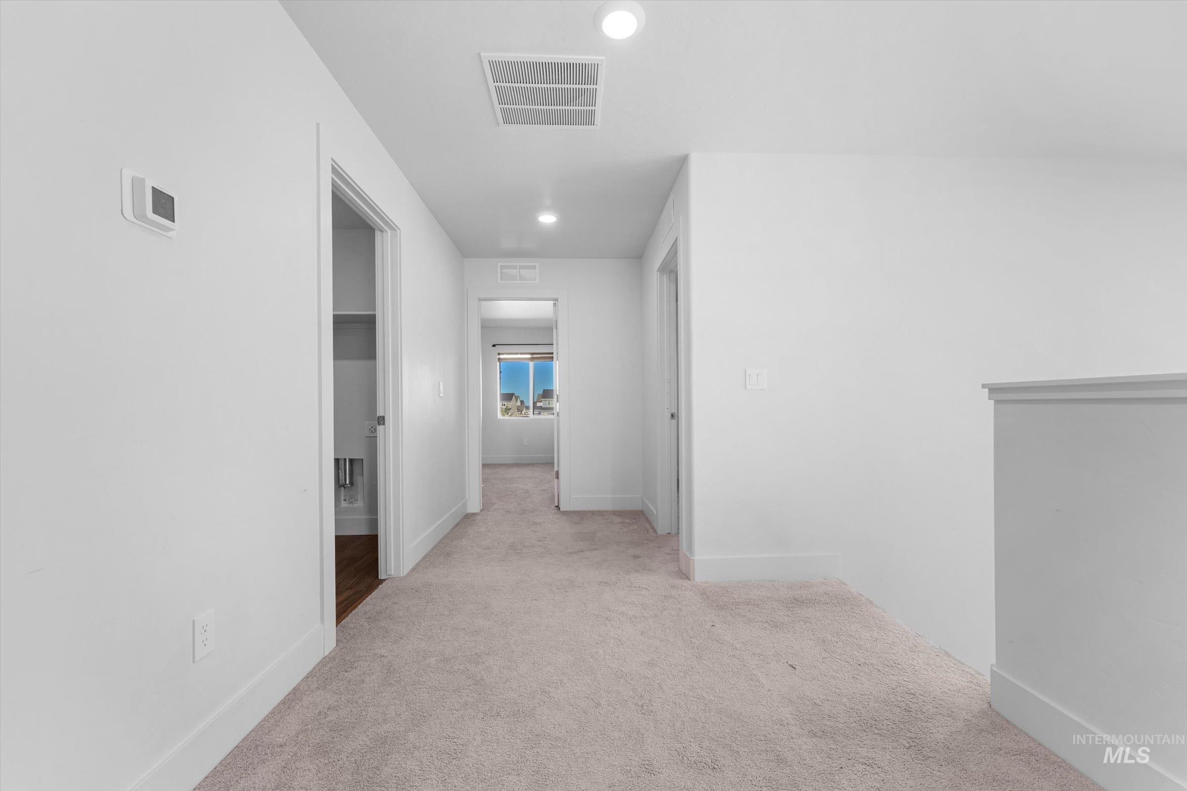 Hallway featuring light carpet and recessed lighting