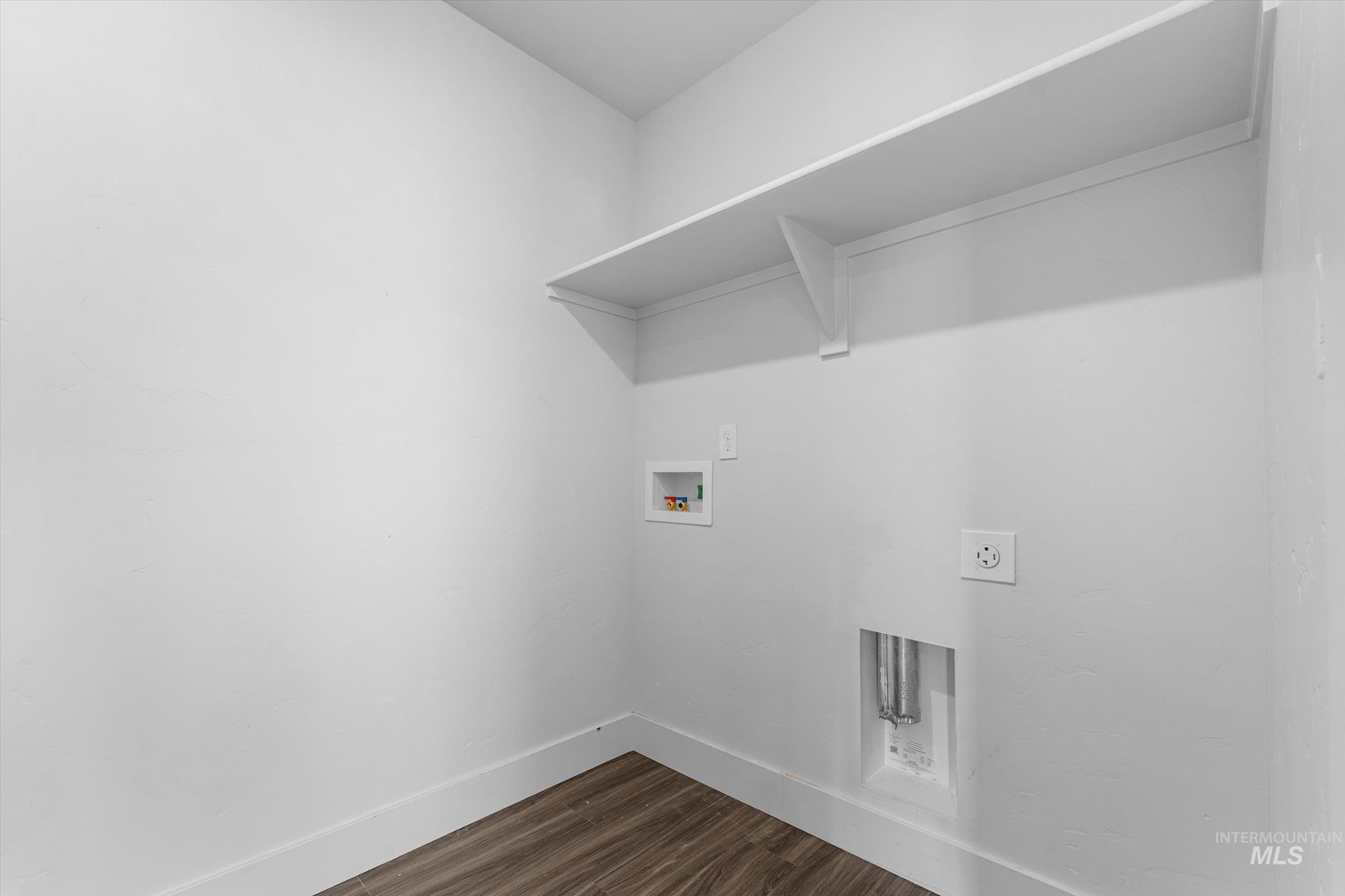 Laundry room with dark wood finished floors, washer hookup, and hookup for an electric dryer