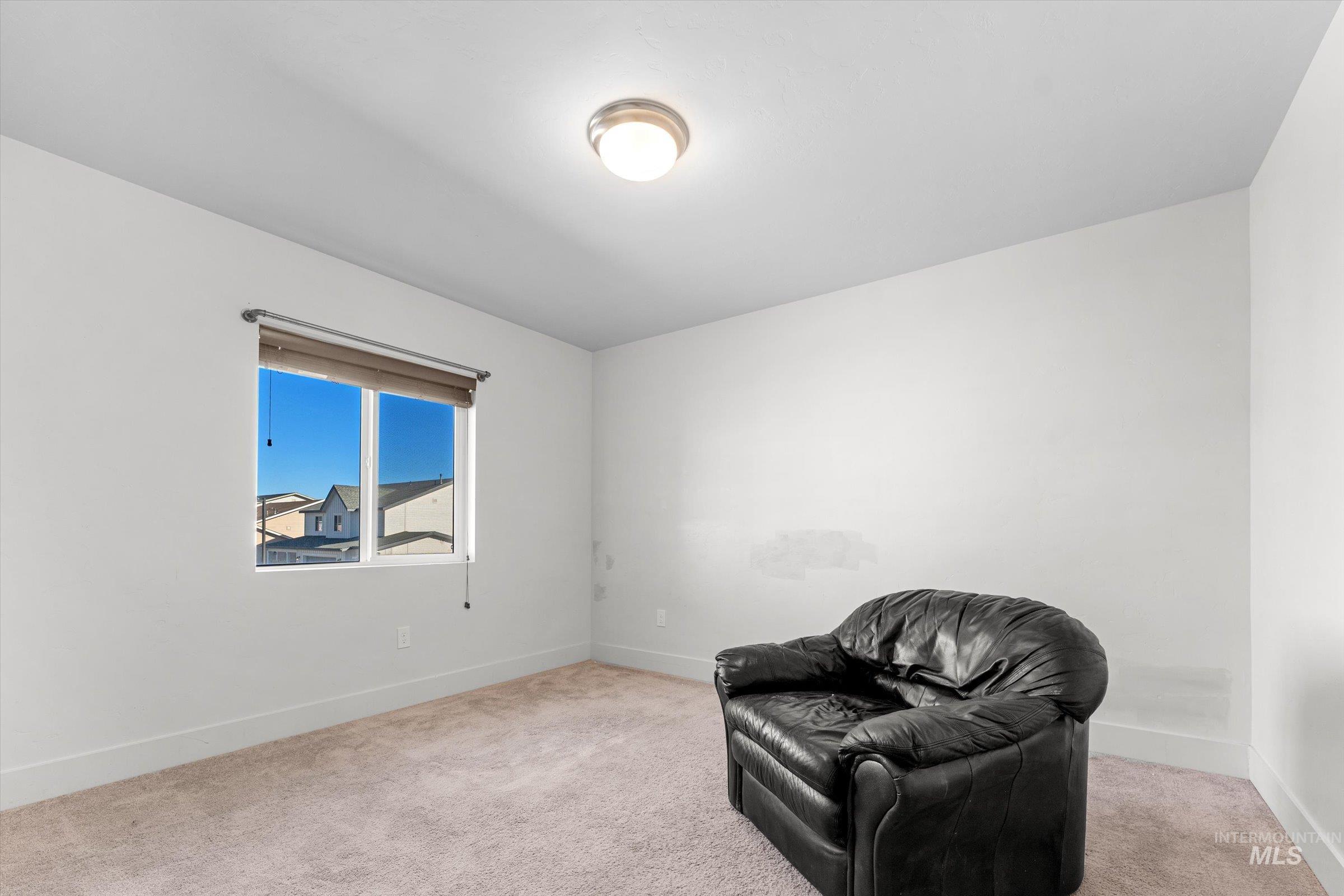 Sitting room featuring light carpet and baseboards
