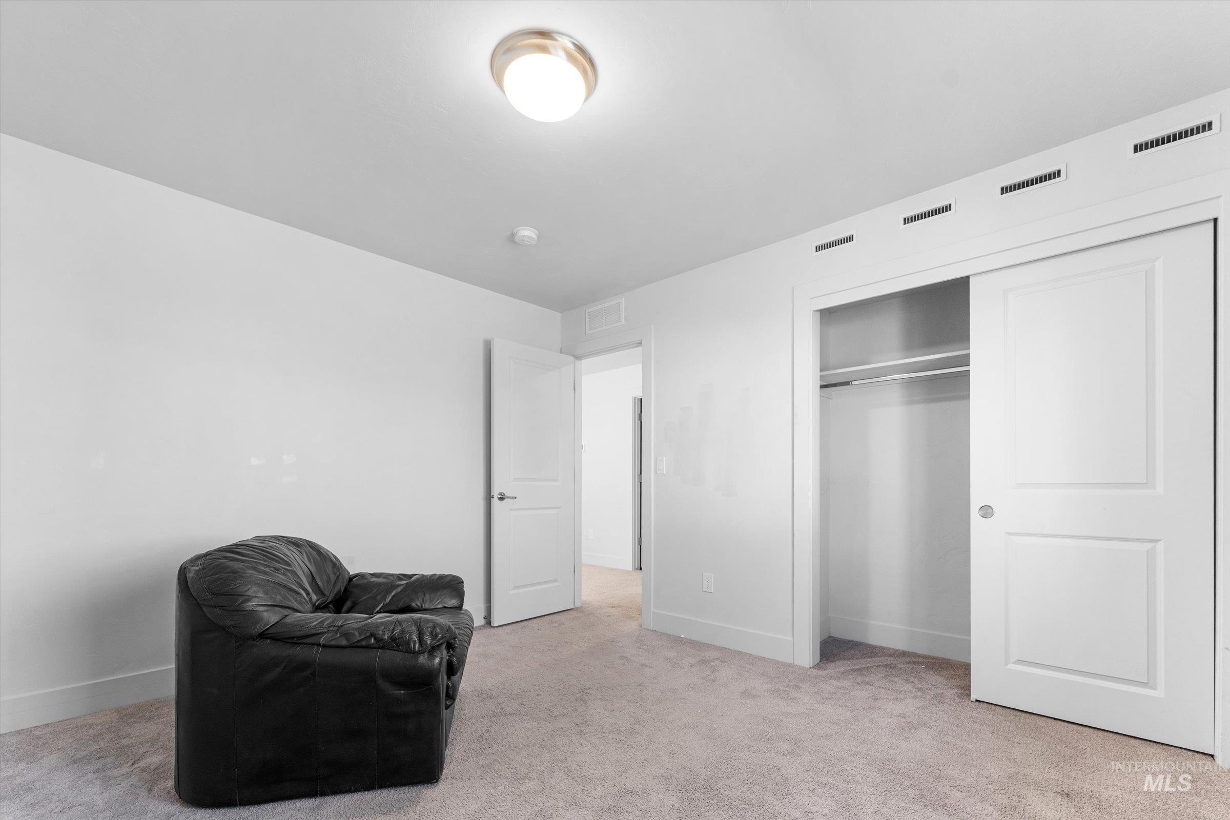 Sitting room featuring light colored carpet and baseboards