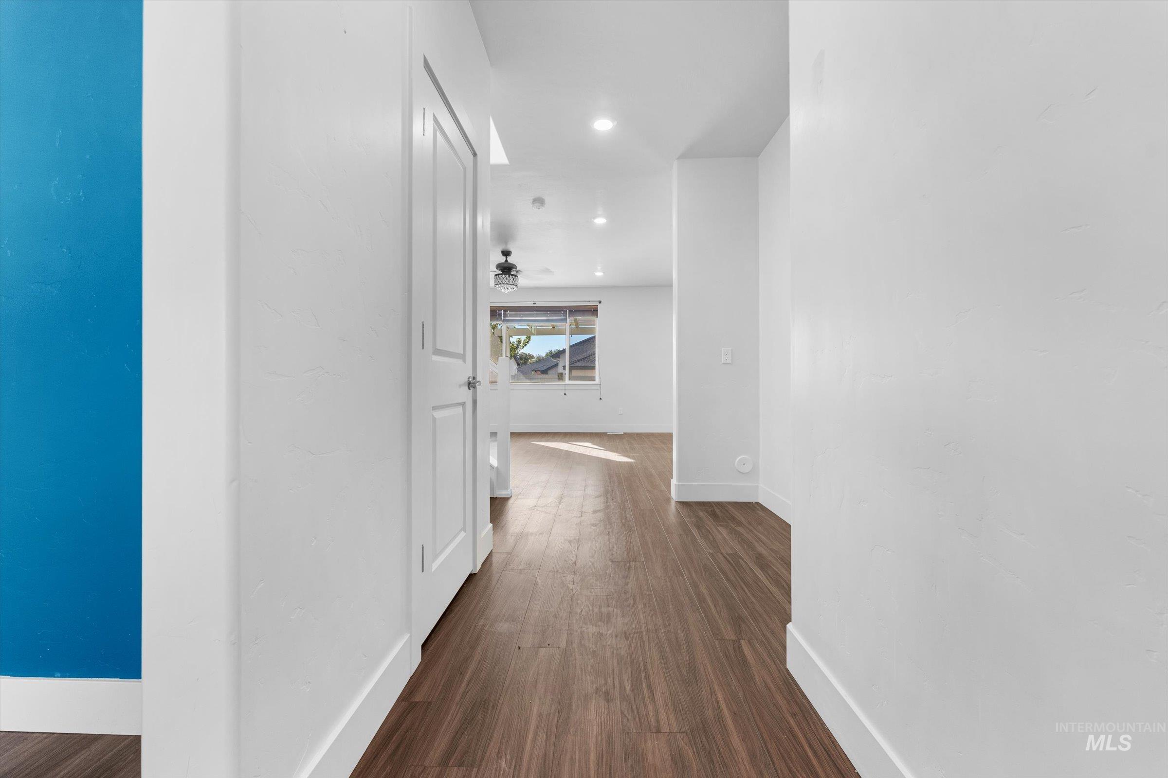 Corridor with dark wood-style flooring and recessed lighting