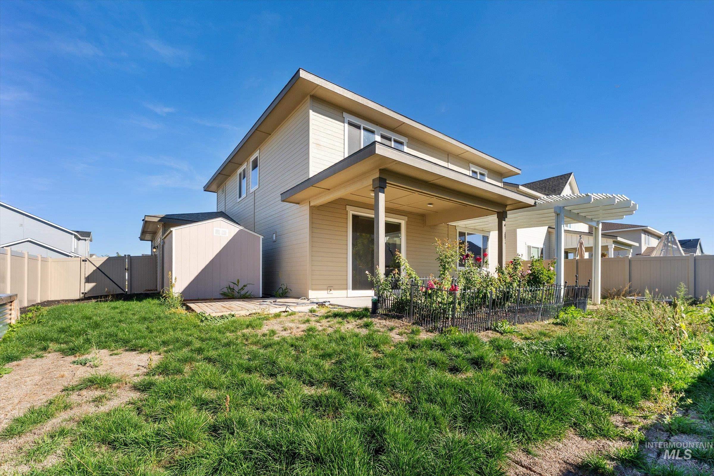Rear view of house with a fenced backyard, a patio area, and a storage unit
