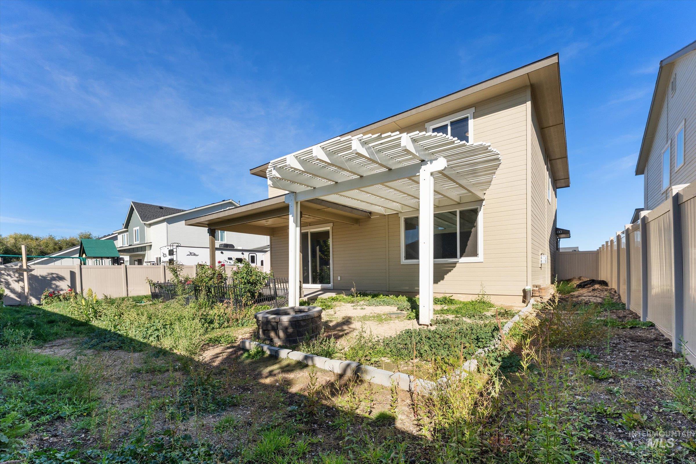 Back of property featuring a fenced backyard, a patio, and a pergola