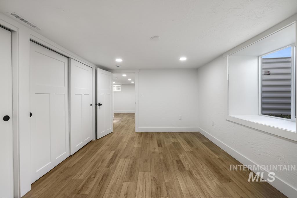 Basement with wood finished floors and recessed lighting