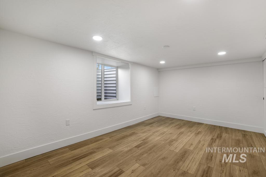 Basement with recessed lighting and light wood-style flooring
