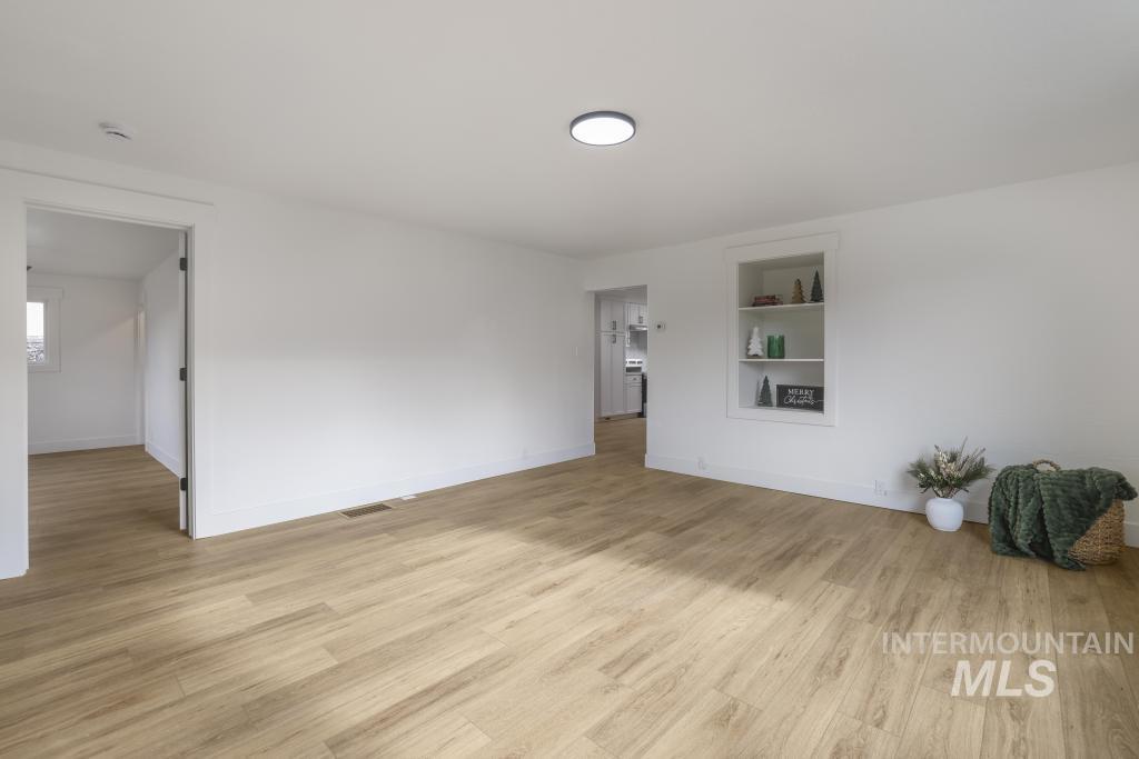 Unfurnished room featuring built in features and light wood finished floors