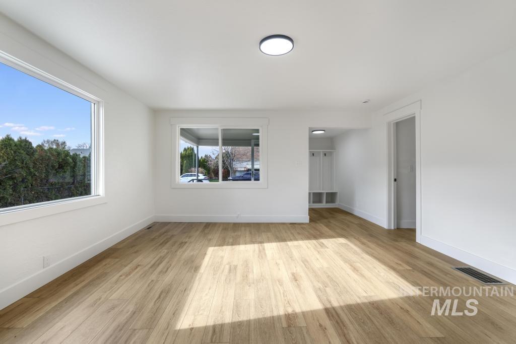 Unfurnished room with light wood-style floors and baseboards